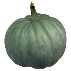 Large green patinated pumpkin in wood