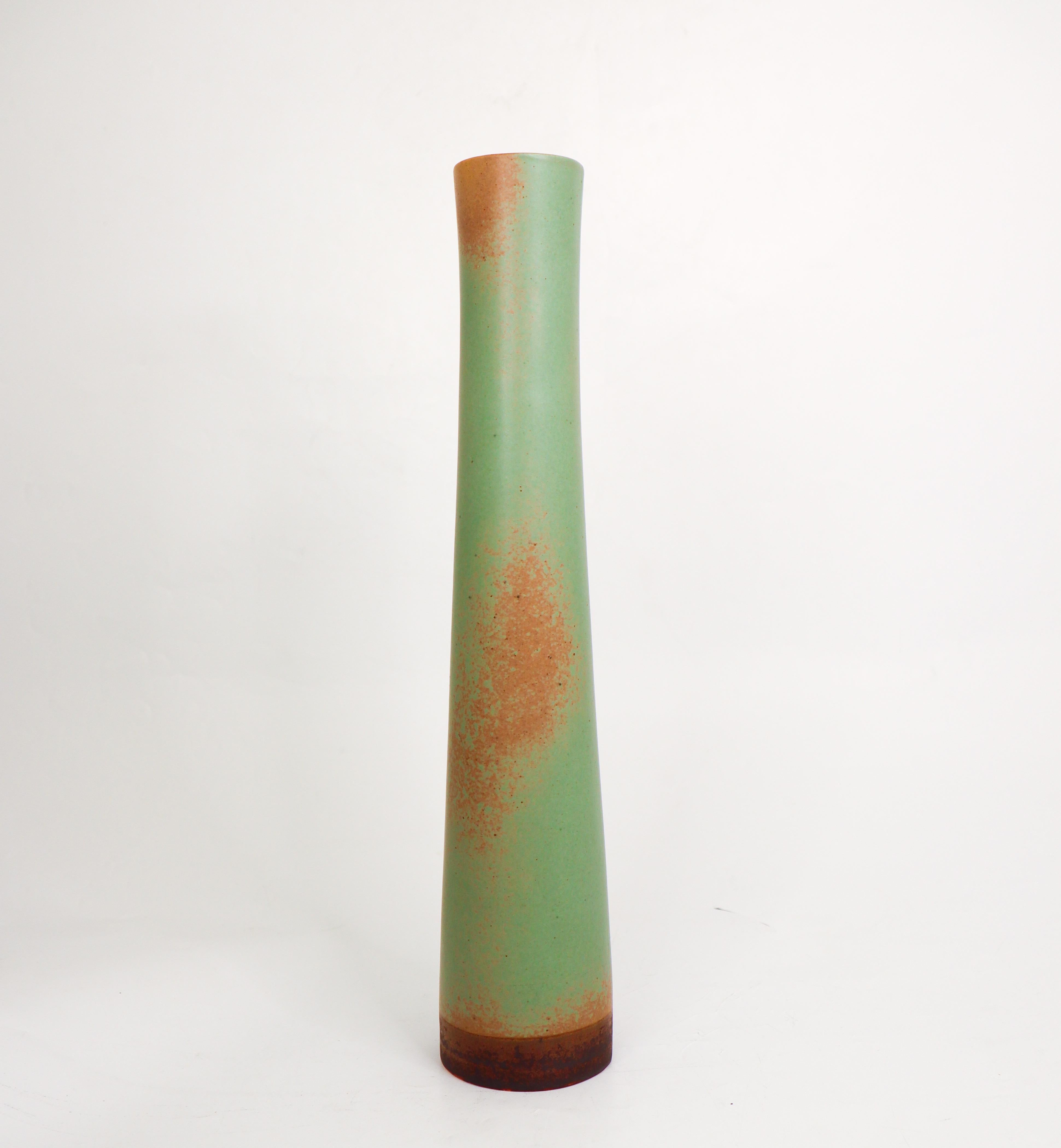 A stunning cylindric vase designed by Annikki Hovisaari at Arabia in Finland in the Mid 20th century. The vase has a stunning matte green glaze, it is 36 cm (14,4