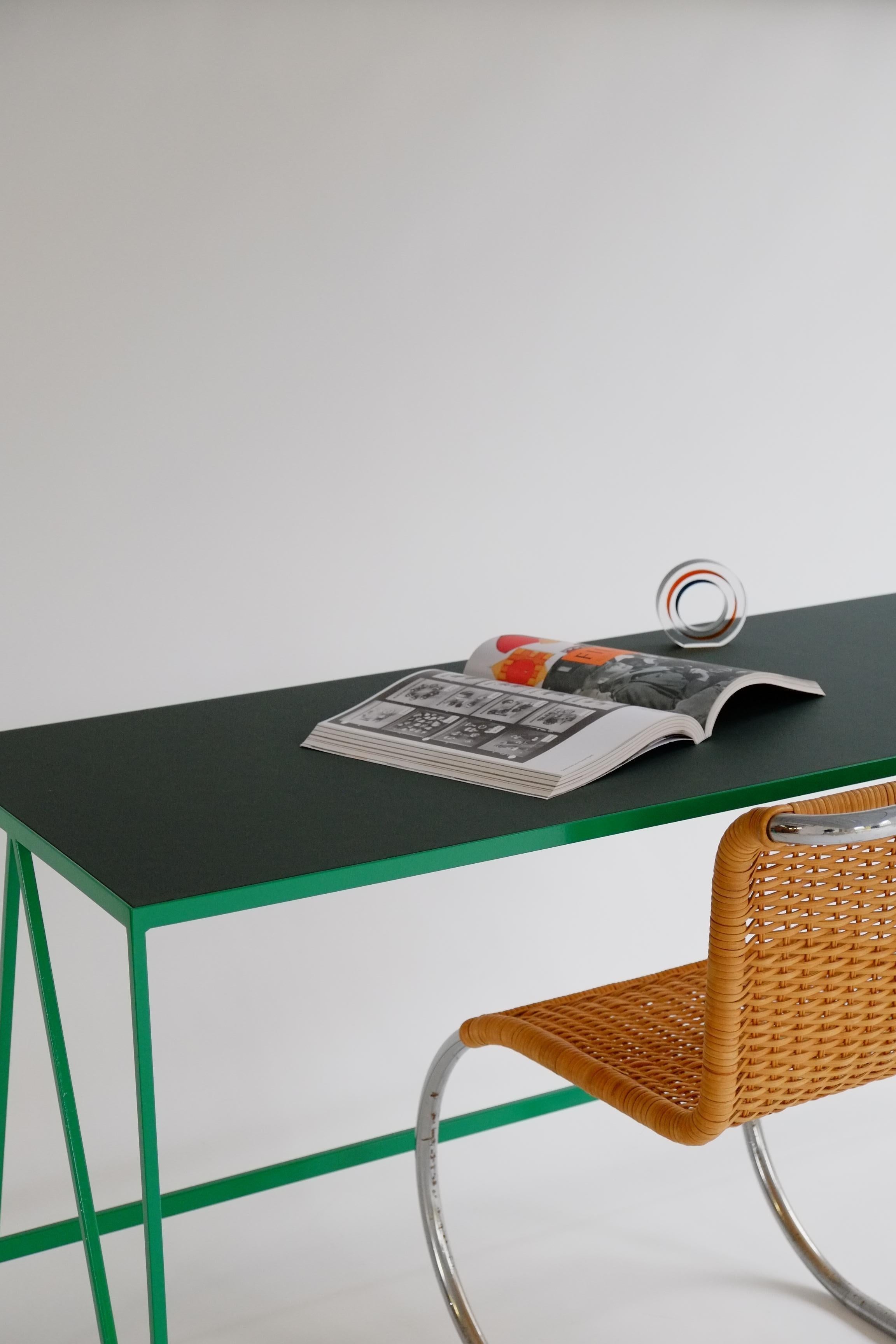 Este gran escritorio de estudio está fabricado con una estructura de acero con recubrimiento en polvo de color verde brillante y un tablero de linóleo verde intenso hecho con ingredientes totalmente naturales, como lino, harina de madera y piedra
