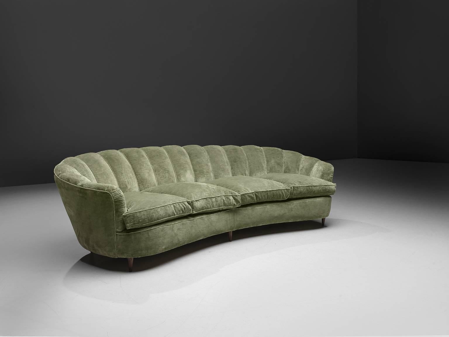Sofa, green velvet, wood, Italy, 1950s.

This voluptuous sofa is executed with small wooden legs and shimmering green velvet fabric. The sofa has a webbed, curved back and a very thick body, both the back and armrests are bulky, strong and wide.