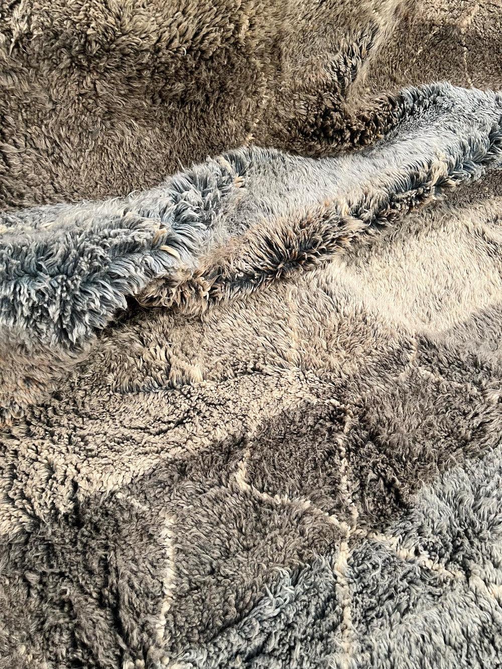 Esta alfombra neutra extragrande tejida a mano en Beni Ourain fue fabricada a mano por hábiles artesanos de la cordillera del Atlas con lana marroquí de la mejor calidad. Impresiona tanto por su tamaño como por su diseño, y es la pieza de lujo