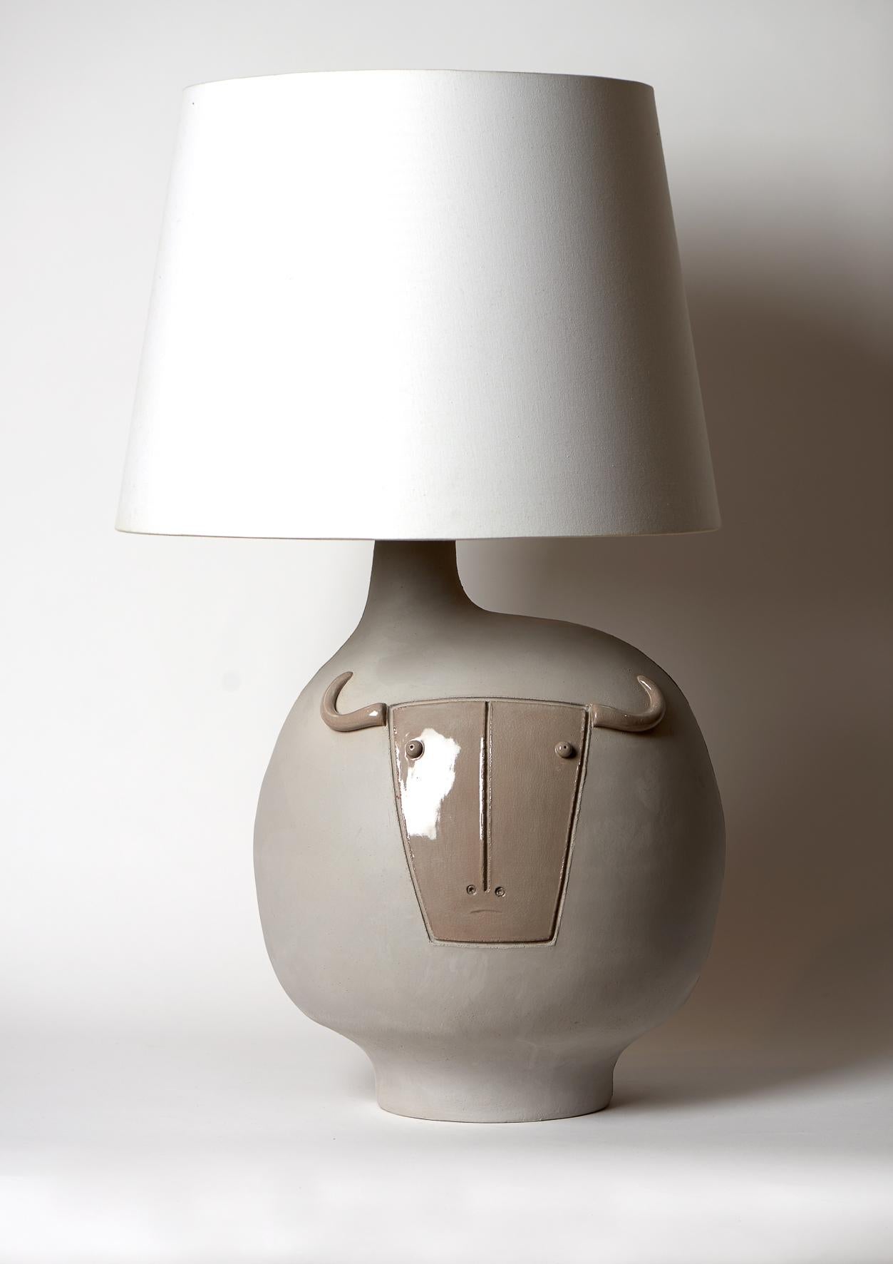 A sculptural lamp-base, natural warm grey stoneware, stylized form, decorated on front with a stylized Toro incised and over-glazed in shiny grey. Back in shiny grey too.

 One of a kind handmade piece, signed by the French ceramicists: Daniel and