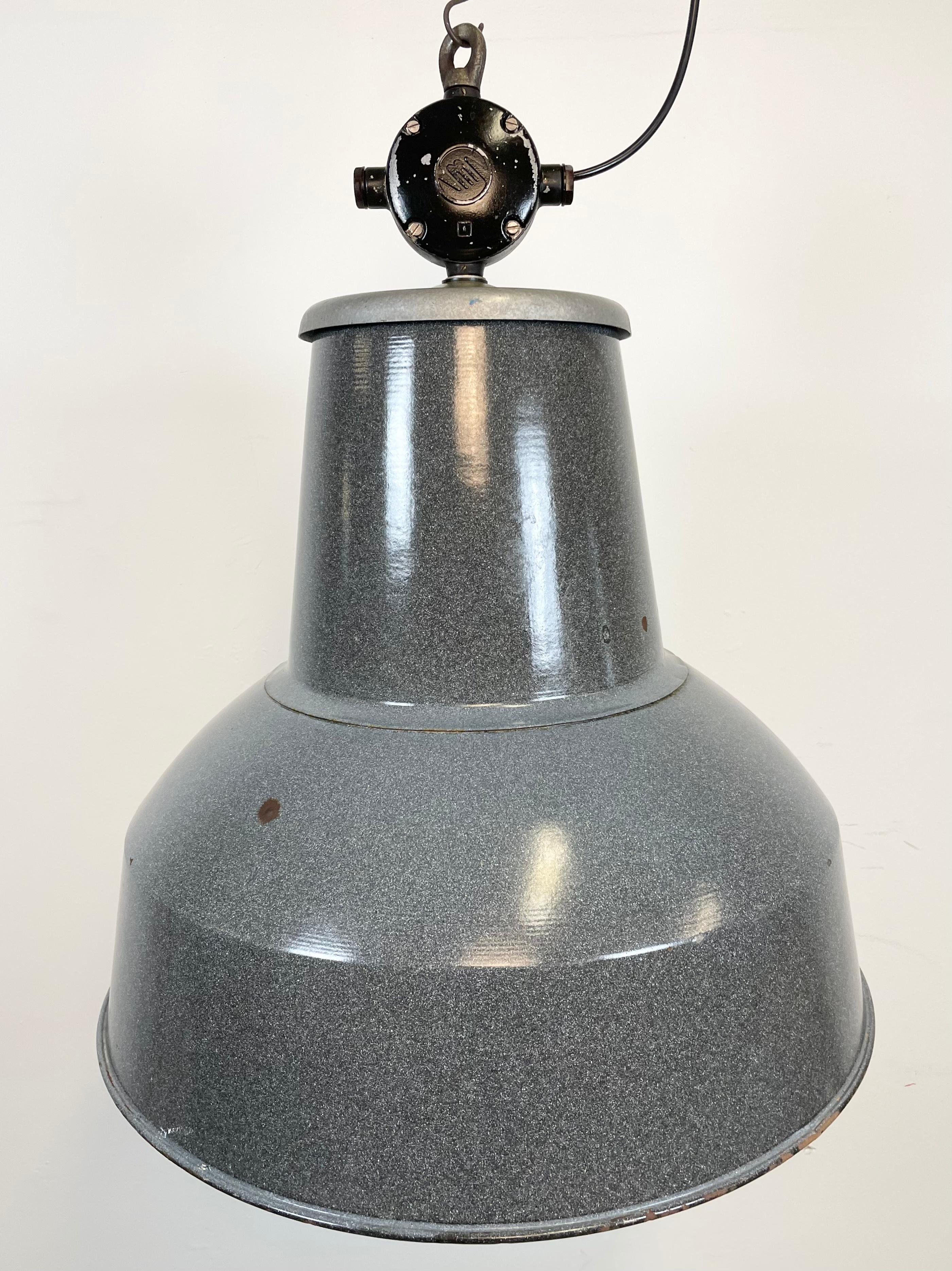 This grey industrial pendant light was designed in the 1960s and produced by Elektrosvit in the former Czechoslovakia. It features a cast aluminium top, a grey enamel exterior and a white enamel interior.
New porcelain socket for E 27 lightbulbs