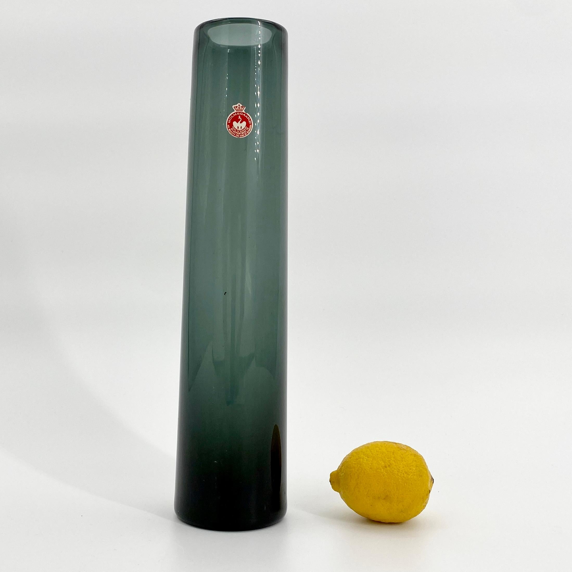 Eine hohe und fein gearbeitete mundgeblasene grüne Glasvase von Holmegaard. Die Vase ist von Holmegaard und Lütken signiert und gekennzeichnet. Form und Farbe der Vase lassen sich am besten als eine sich verjüngende Form mit hellgrauem und grünem