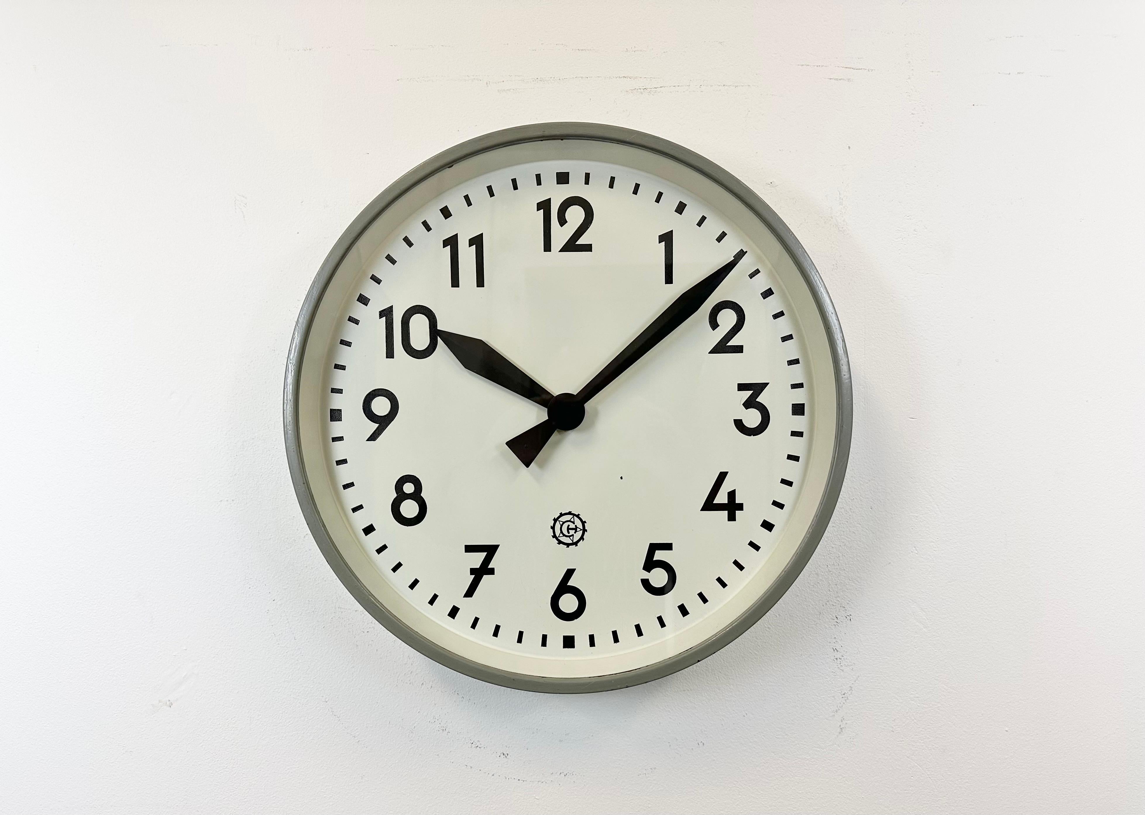 This wall clock was produced by Chronotechna in former Czechoslovakia during the 1950s. It features a grey metal frame, an iron dial,an aluminium hands and a clear glass cover. The piece has been converted into a battery-powered clockwork and