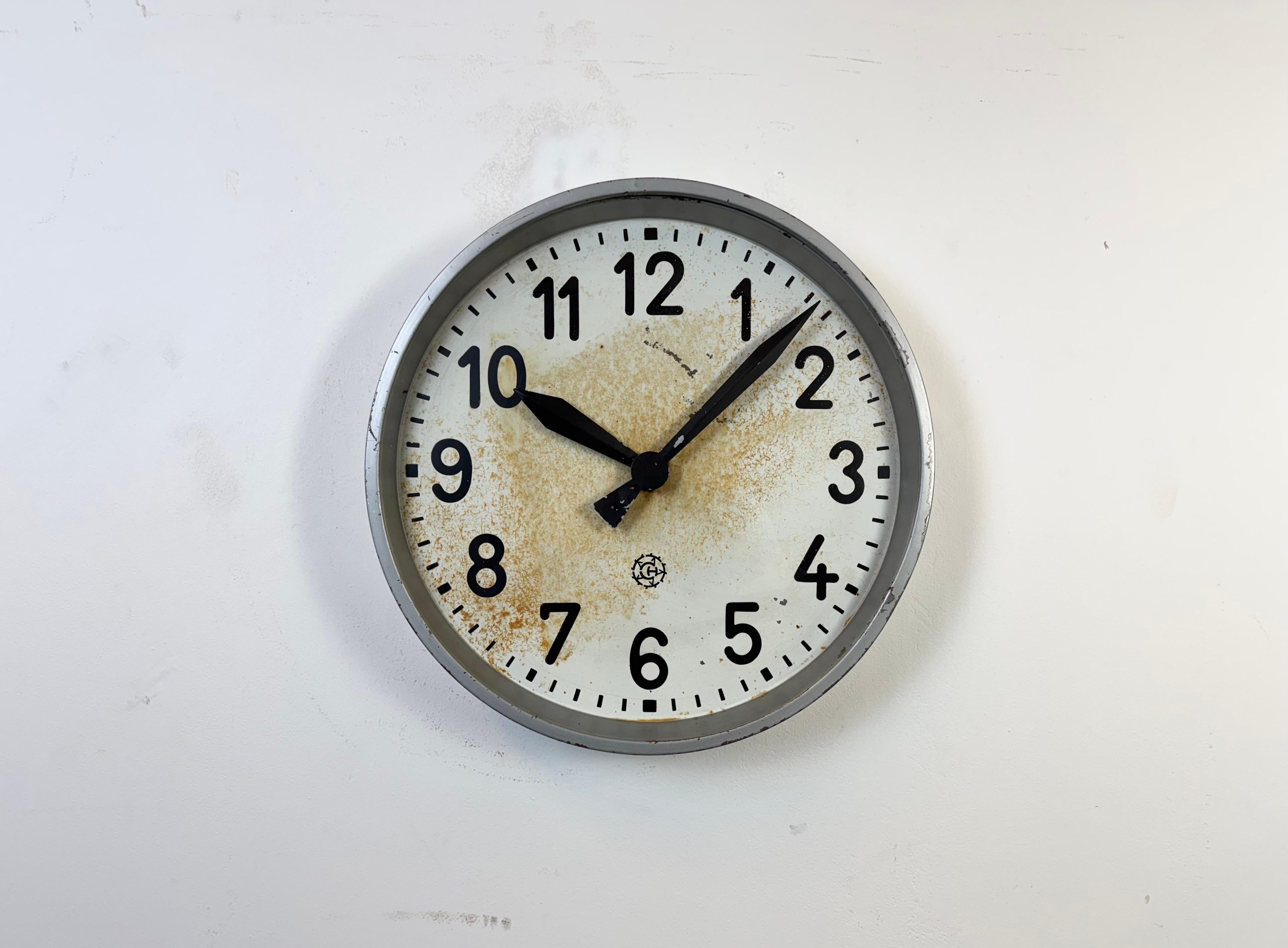 Cette horloge murale a été produite par Chronotechna dans l'ancienne Tchécoslovaquie au cours des années 1950. Elle se compose d'un cadre en métal gris, d'un cadran en fer, d'aiguilles en aluminium et d'un couvercle en verre transparent. La pièce a