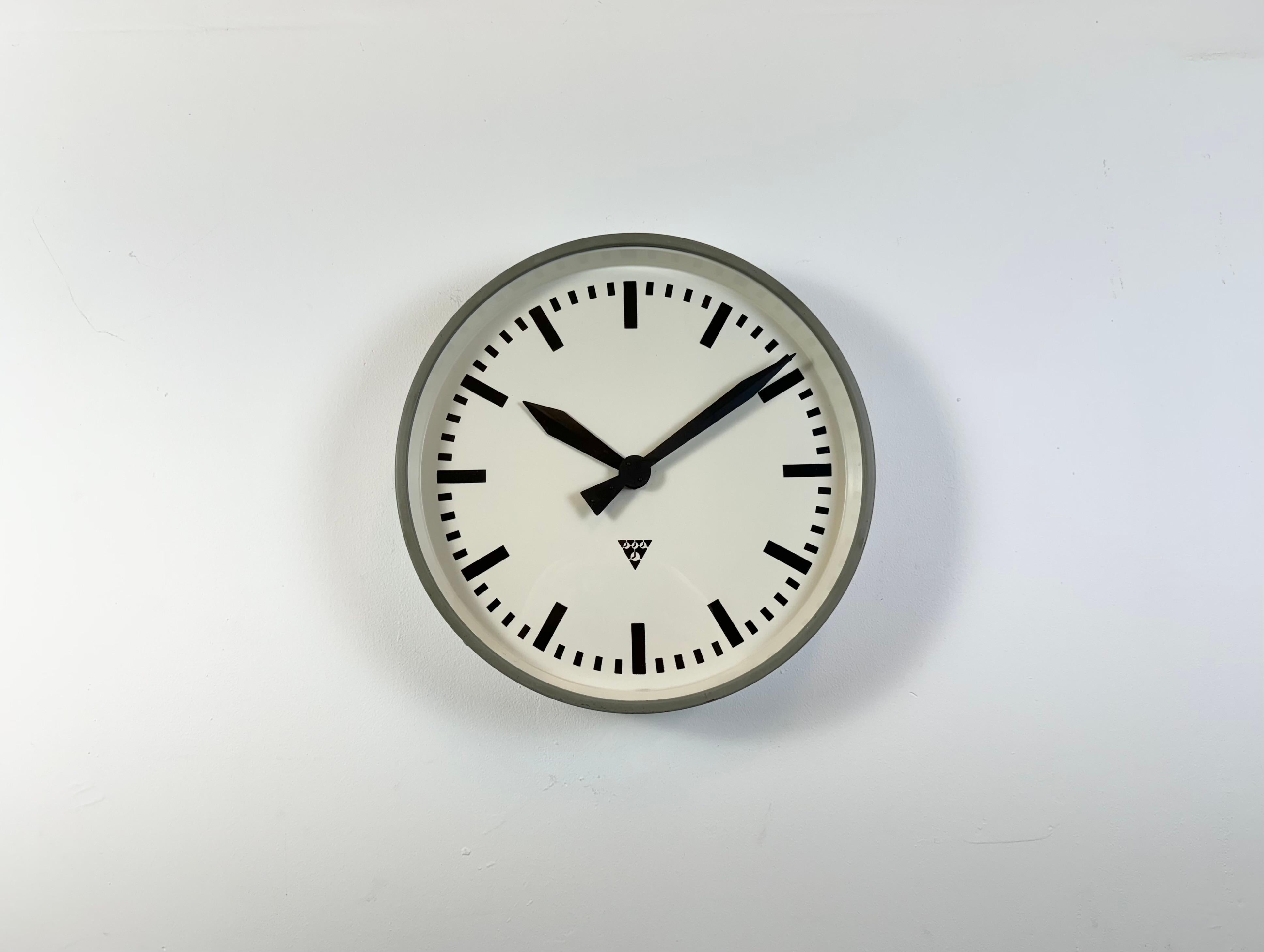 Horloge murale Pragotron fabriquée dans l'ancienne Tchécoslovaquie dans les années 1960. Il se compose d'un corps en métal gris, d'un cadran en métal et d'un couvercle en verre transparent. La pièce a été convertie en un mécanisme d'horlogerie