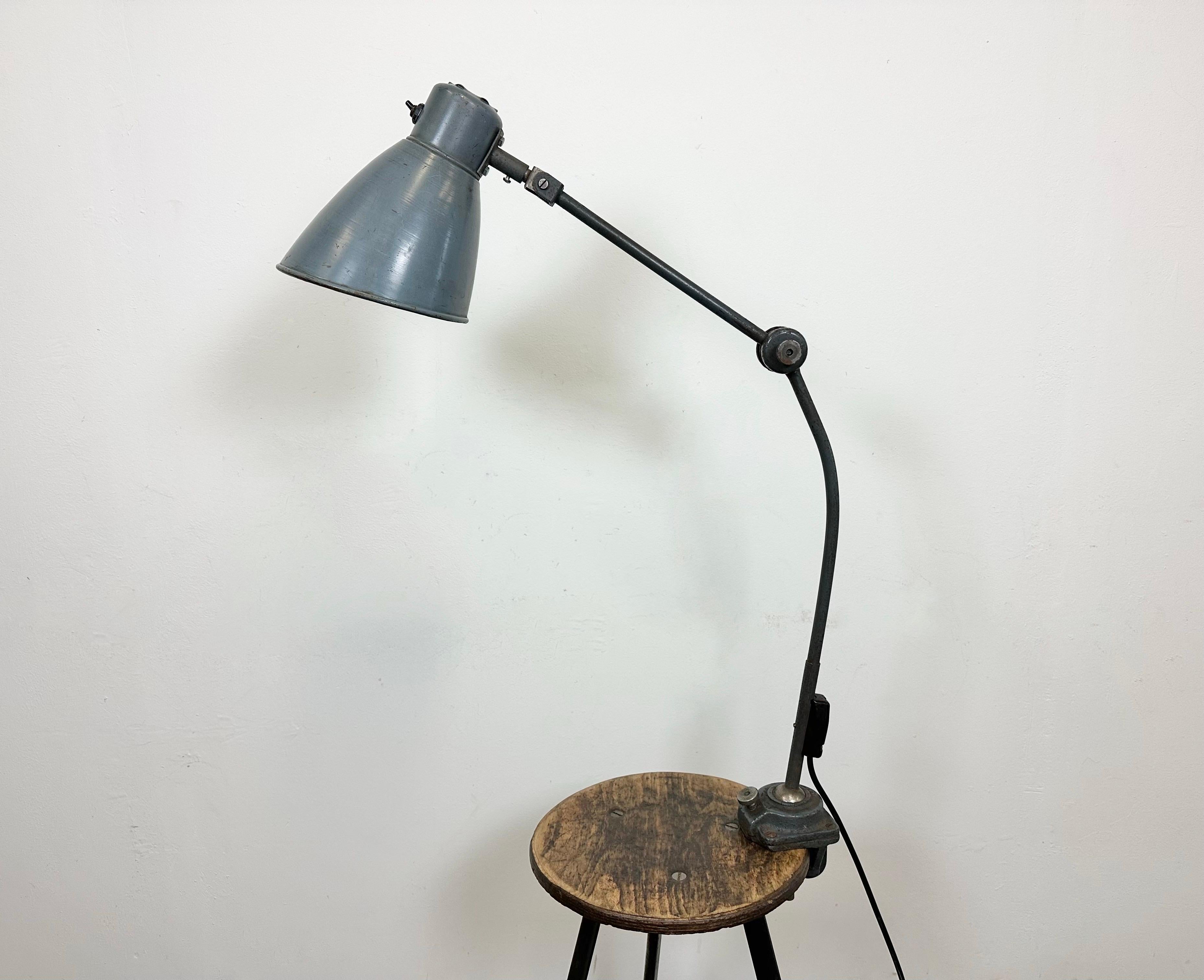 Large industrial table lamp with three adjustable joints made in former Czechoslovalia during the 1960s.It features a grey iron base ,arm and lampshade. The porcelain socket requires E 27/E 26 light bulbs. New wire. The diameter of the shade is 17