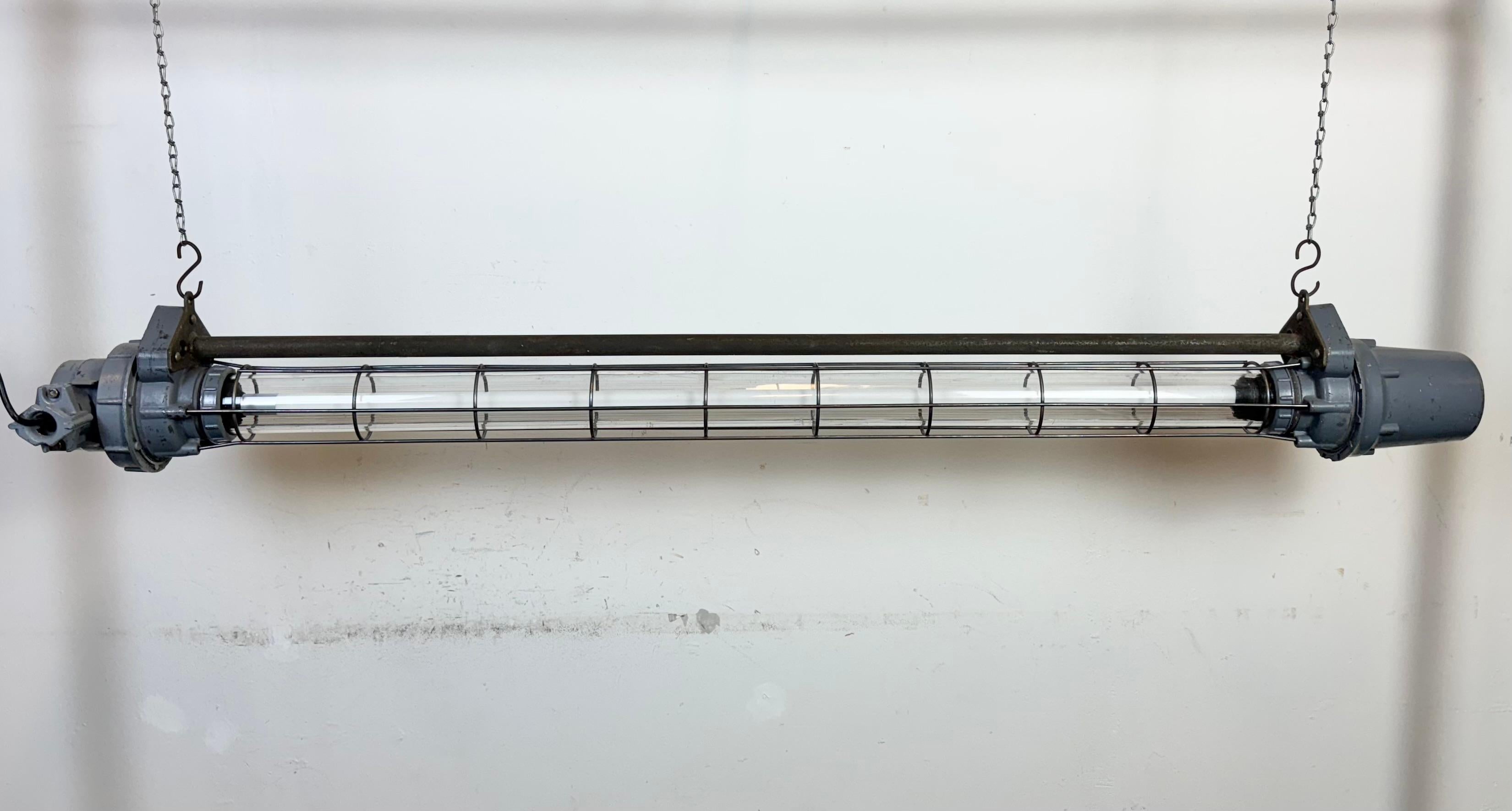 Este tubo de luz industrial gris se fabricó en Ucrania, en la antigua Unión Soviética, durante la década de 1970. Está fabricado en aluminio, vidrio plástico y hierro. La luz se convierte en un Led  120 cm T8  El peso de la lámpara es de 8,9 kg. El