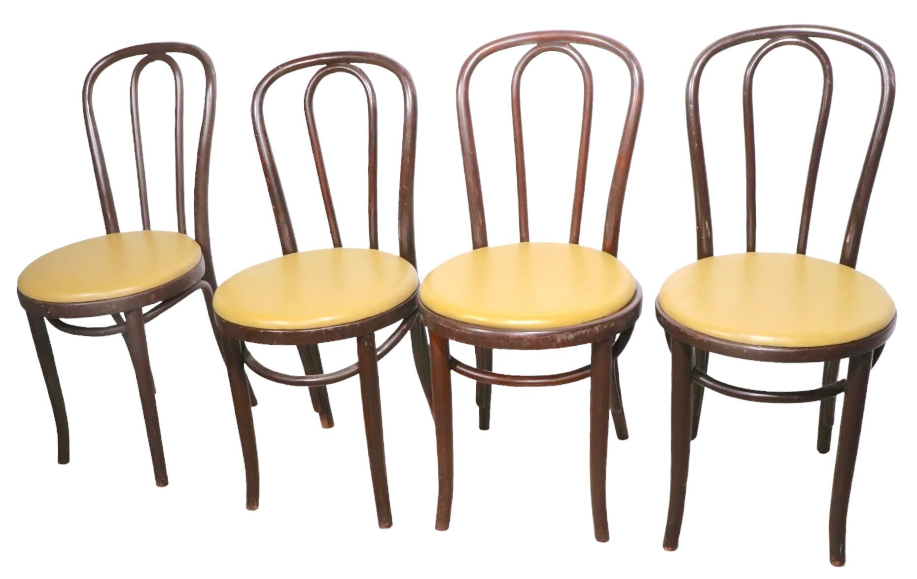 Set of 10 cafe, bistro style dining chairs of steam bent wood frames, with vinyl pad seats. The chairs are in very good, vintage condition showing expected cosmetic wear to finish, but are structurally sound and sturdy. These chairs are priced and