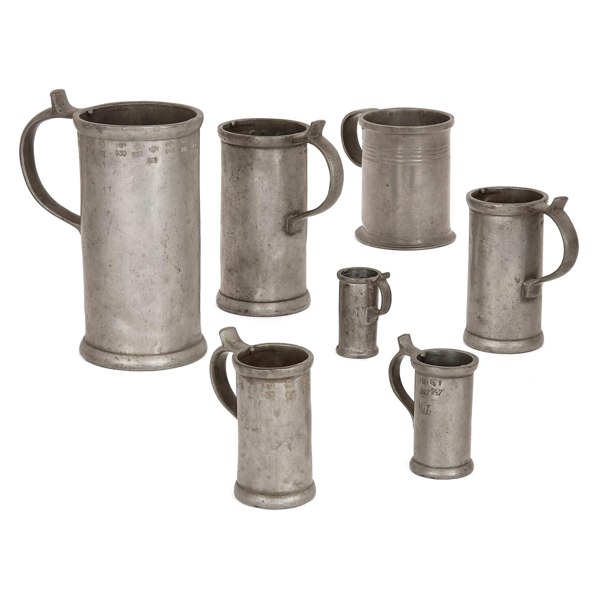 Gran grupo de tazas, jarras y aguamaniles antiguos alemanes de peltre
Alemán, siglos XVIII y XIX
Jarra más grande: Altura 29 cm, anchura 24 cm, profundidad 15 cm
Jarra más pequeña: altura 6,5 cm, anchura 5 cm, profundidad 3 cm

Esta colección