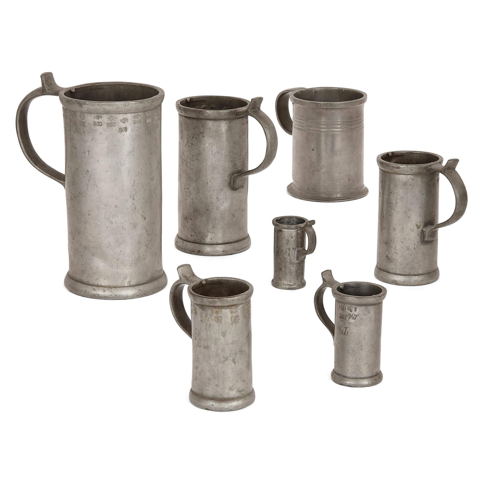 Grand groupe de tasses, de chopes et d'aiguières allemandes anciennes en étain
Allemand, XVIIIe et XIXe siècles
La plus grande cruche : Hauteur 29 cm, largeur 24 cm, profondeur 15 cm
Plus petite chope : hauteur 6,5 cm, largeur 5 cm, profondeur 3