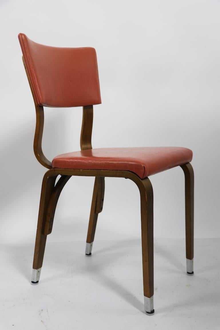 Wonderful large group of Mid-Century cafe dining chairs by Thonet.Salmon vinyl seats and backrests on bent plywood frames, legs have decorative metal end caps, All are in very good, original condition, clean and ready to use. Sexy chic and elegant -