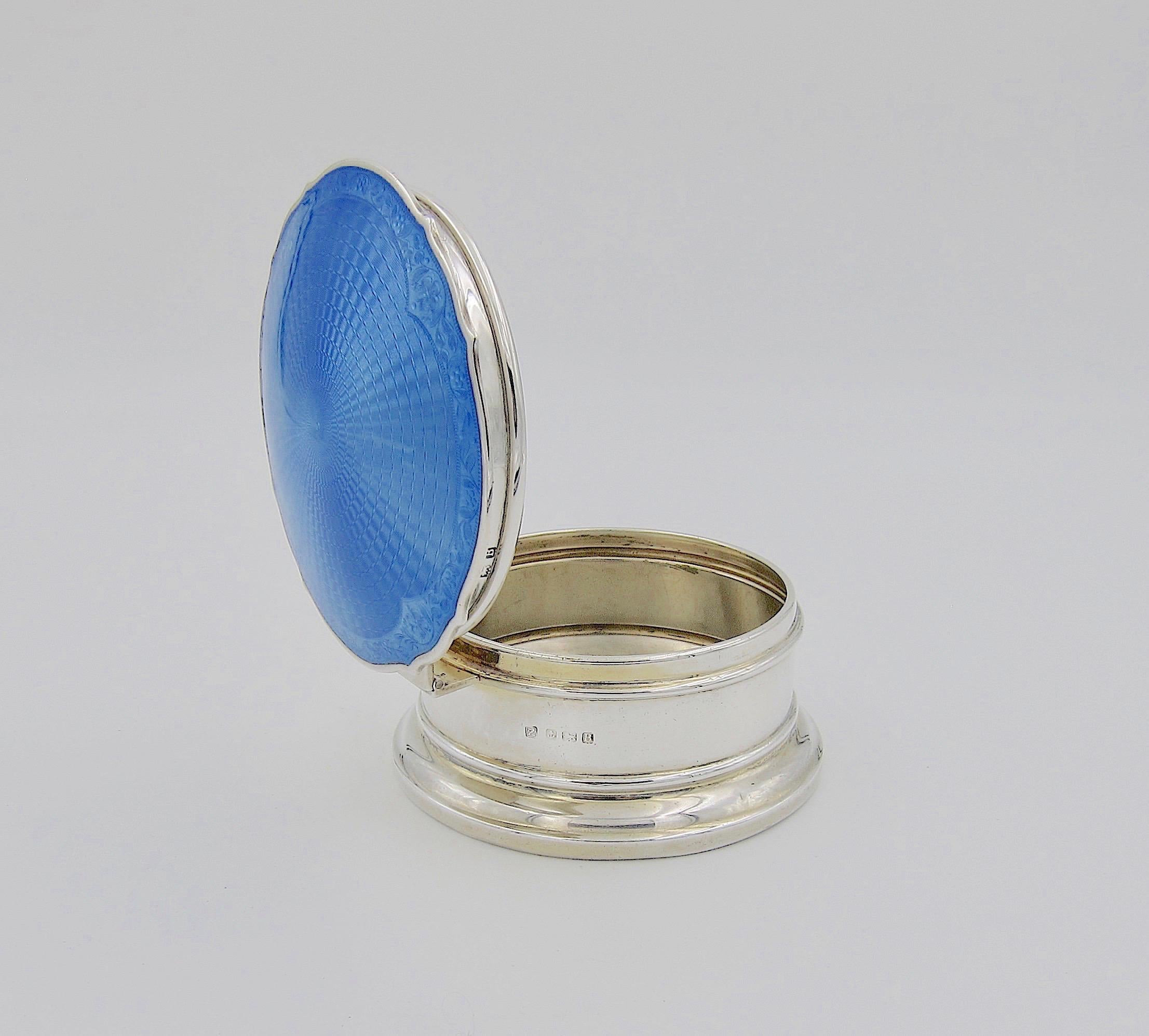 An English Art Deco sterling silver and guilloche enamel hinged circular box from A & J Zimmerman silversmiths of London and Birmingham, date marked 1926. At 4 inches diameter, the piece is an ideal size for storing keepsakes or jewelry; it would