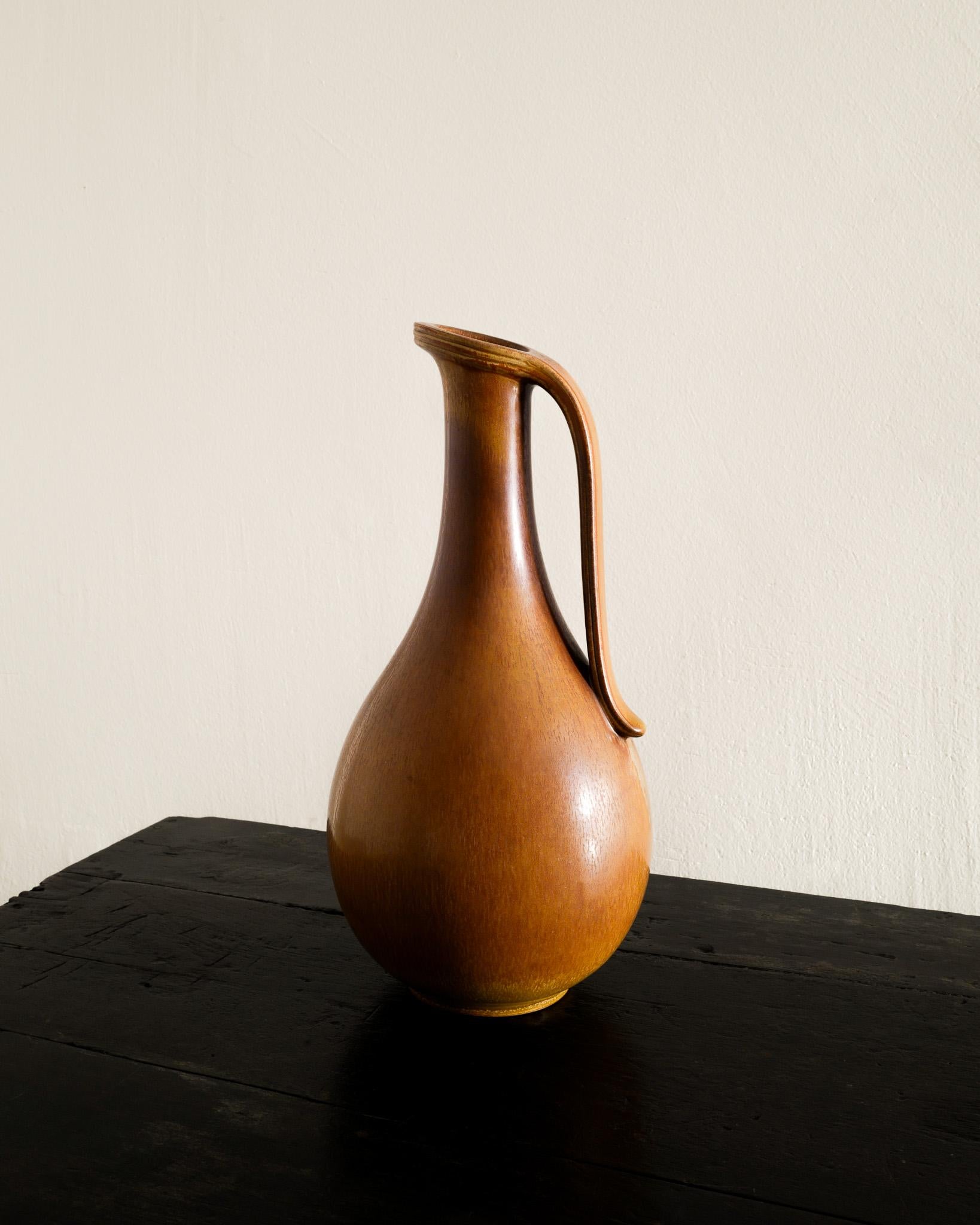 Rare and large mid century brown glazed ceramic pitcher by Gunnar Nylund for Rörstrand Sweden, 1950s. In good original condition. Signed. 

Dimensions: H: 35 cm / 13.75