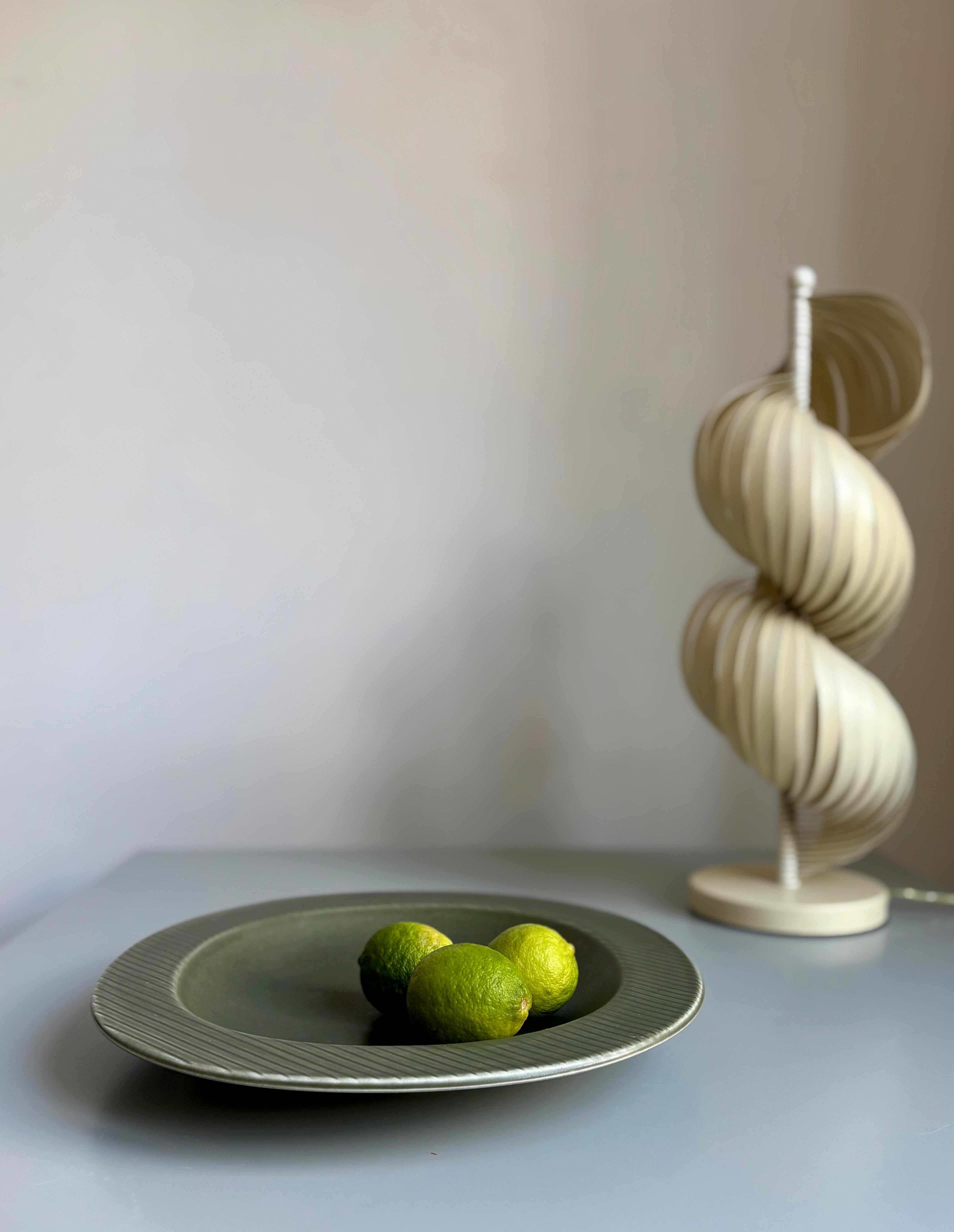 Muted sage olive green stoneware plate with ribbed diagonal edges under the matte glaze. Designed by Gunnar Nylund for Rörstrand’s Ritzi line. Stamped under base. 
Great vintage condition. 
Sweden, 1960s. 
