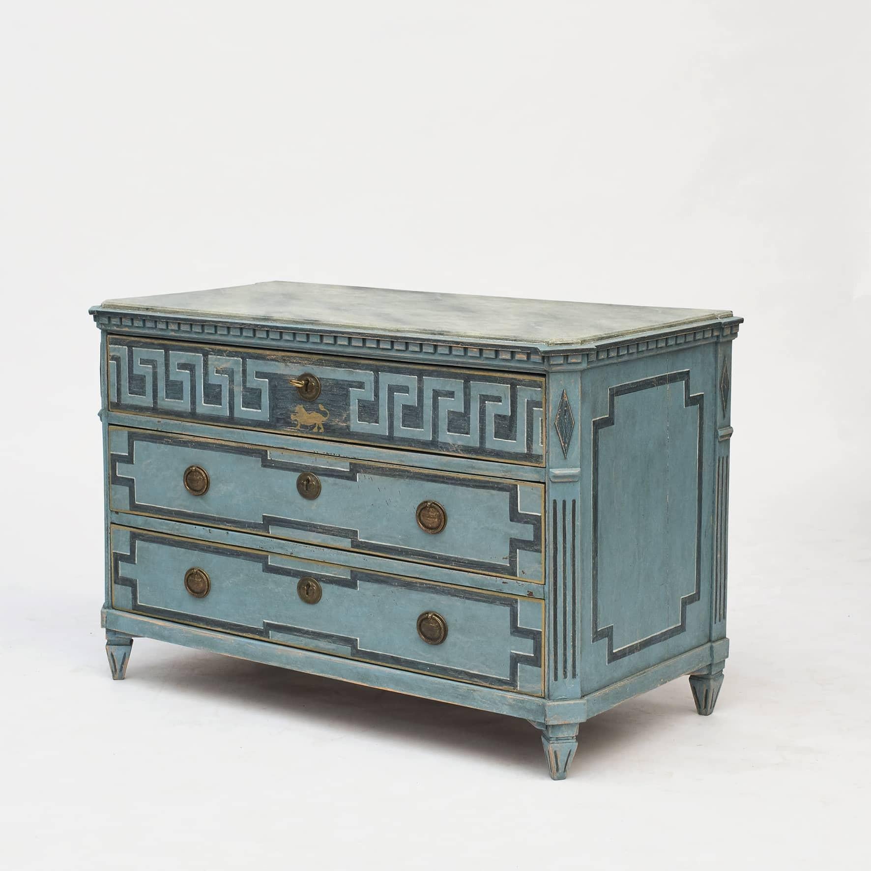A large decorative Swedish Gustavian style chest of drawers painted in blue shades. Wooden gray faux marbled tabletop.
Three drawer, upper drawer decorated with 