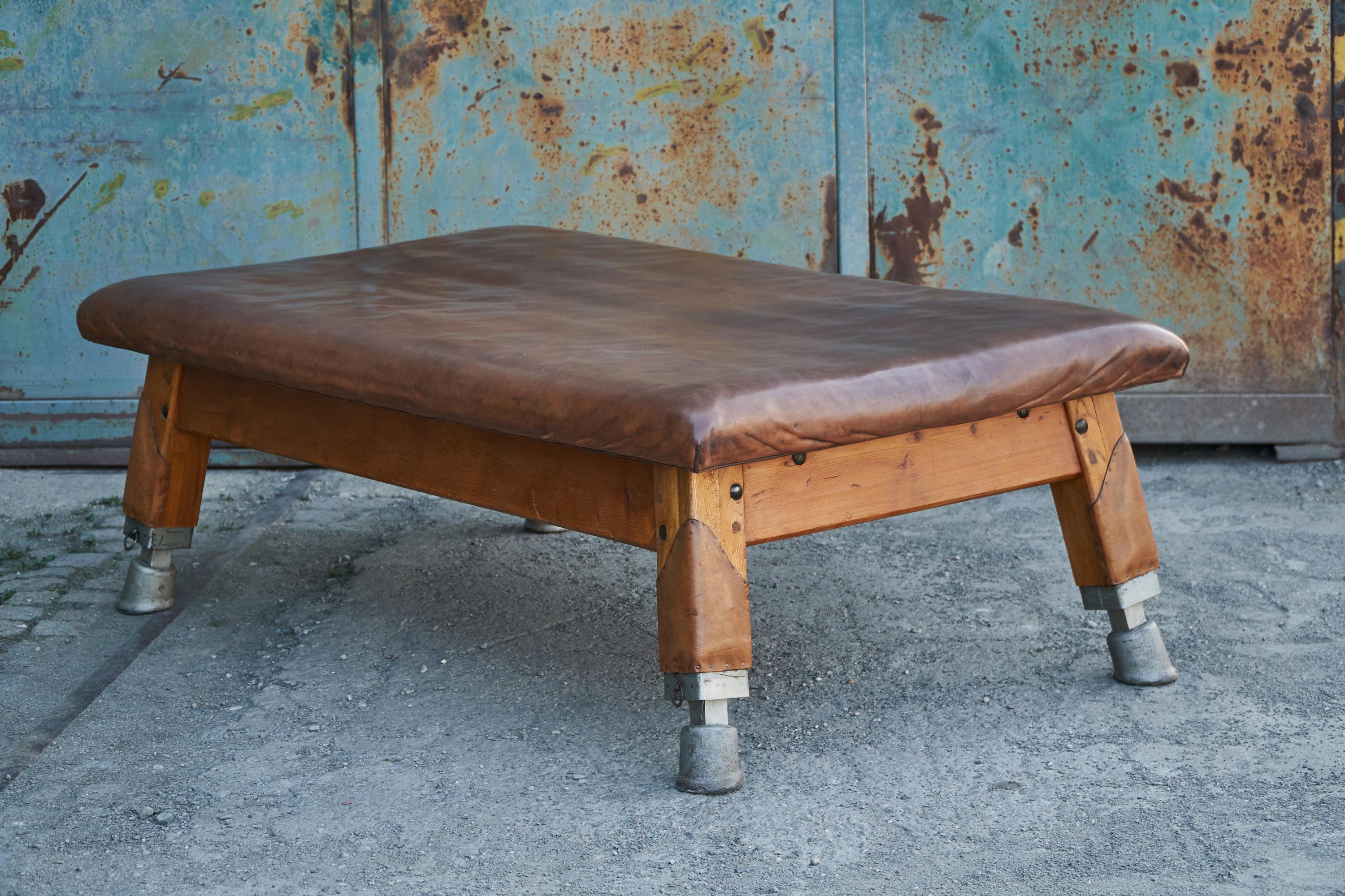 This old tournament table from a Czech school sports hall was cut to a height of 58cm. The leather was cleaned and preserved. The wooden parts restored. The thick cow leather on the top is in good condition. Completely restored.