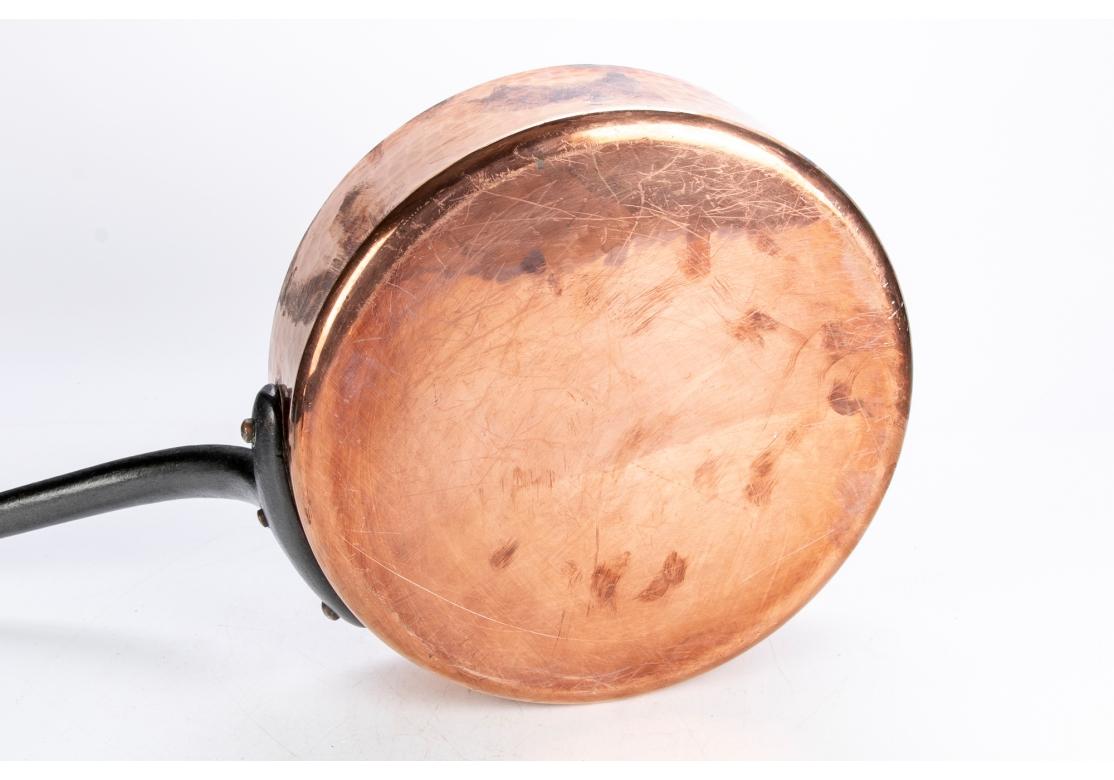 A large heavy hand-hammered copper sauce pan with long curved iron handle. Tin lined. 
Measures: Diameter 13