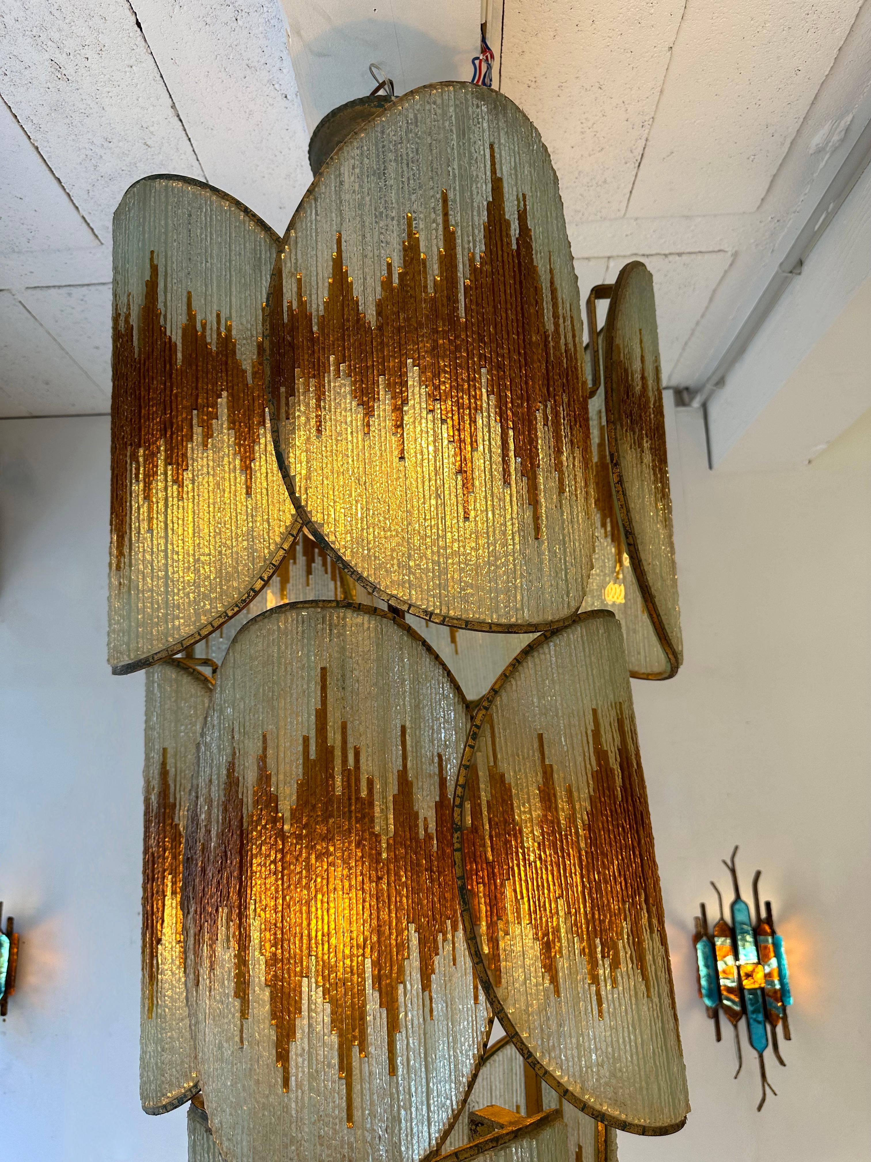 Exceptional, very probably a unique piece. Large Mid-Century Modern chandelier ceiling pendant light lamp in hammered glass and wrought iron, gilding gilt gold patina, by the handmade artisanal italian design manufacture Longobard in Verona in a