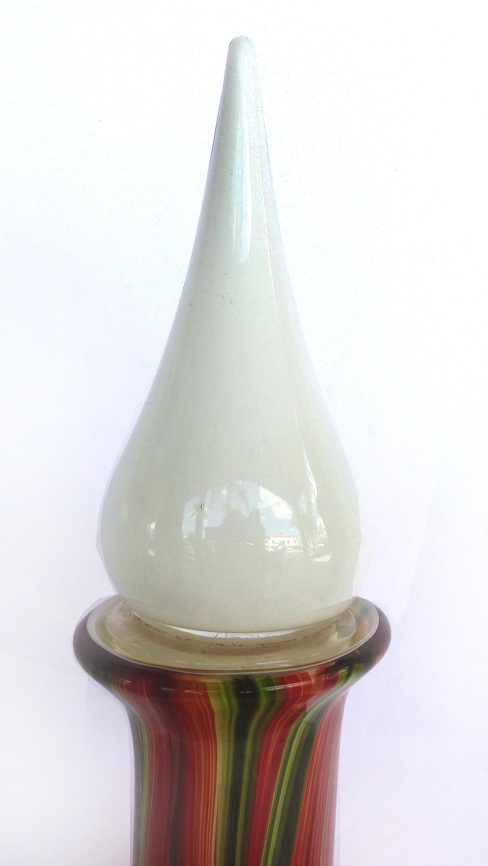 Large Hand Blown Glass Bottle with Stopper

Offered for sale is a large hand blown glass bottle with stopper. This large decorative bottle is brightly colored with red, green and orange stripes and a white milk glass stopper.
