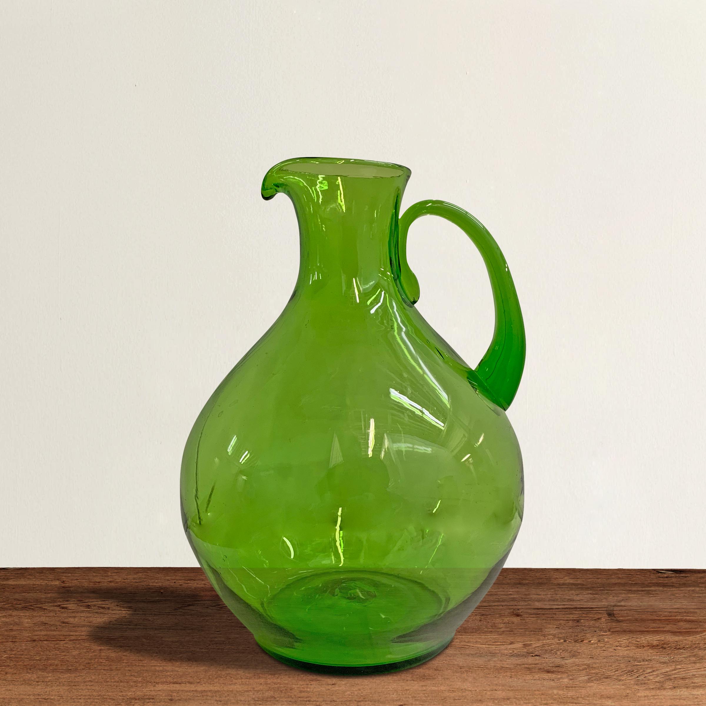 A rather large vintage hand blown green glass pitcher with a narrow neck and wide belly. Perfect as is, filled with flowers, or for serving your favorite libation at your next fête.