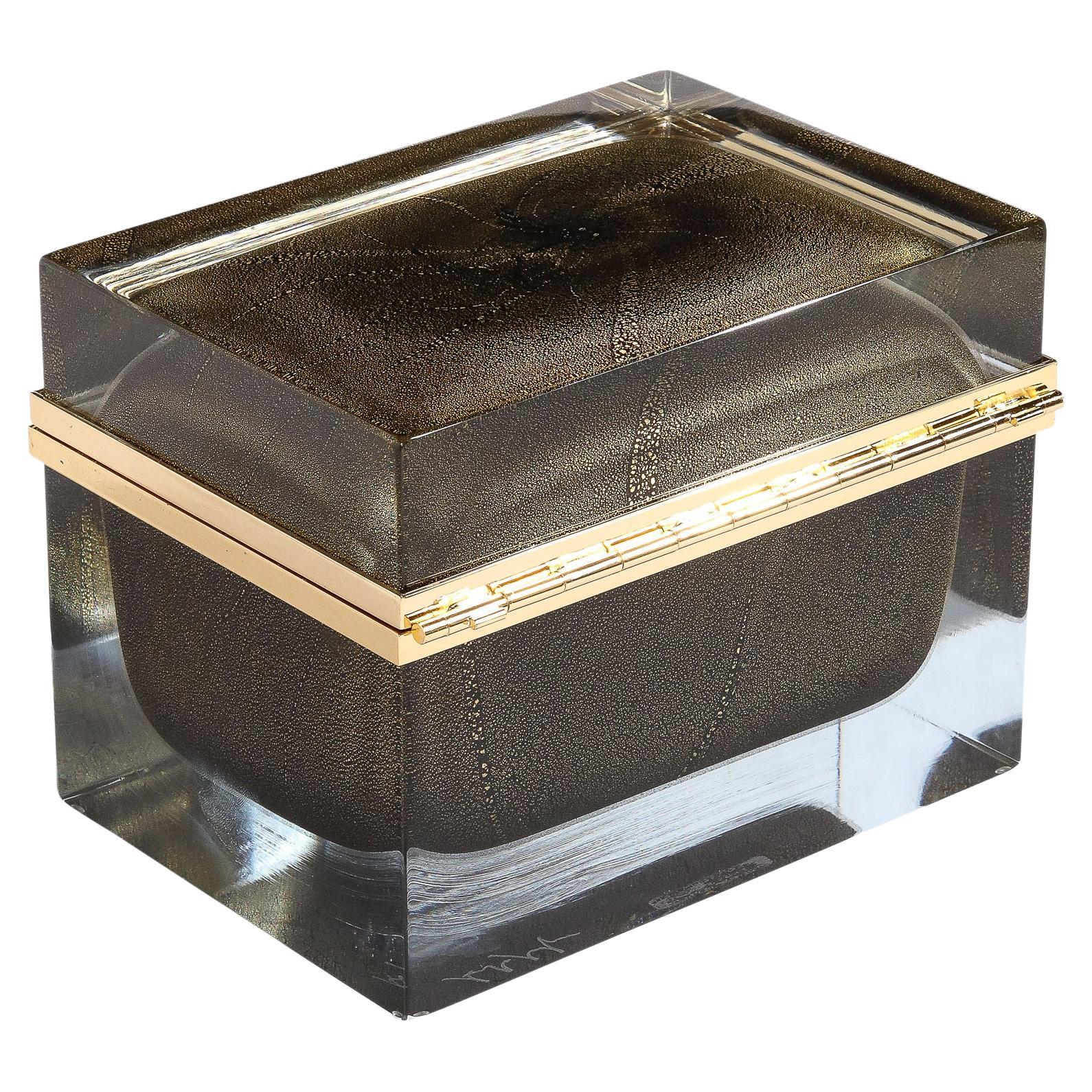 This stunning modernist decorative box was realized in Murano, Italy- the island off the coast of Venice renowned for centuries for its superlative glass production. It features a volumetric rectangular body with a translucent Murano glass exterior