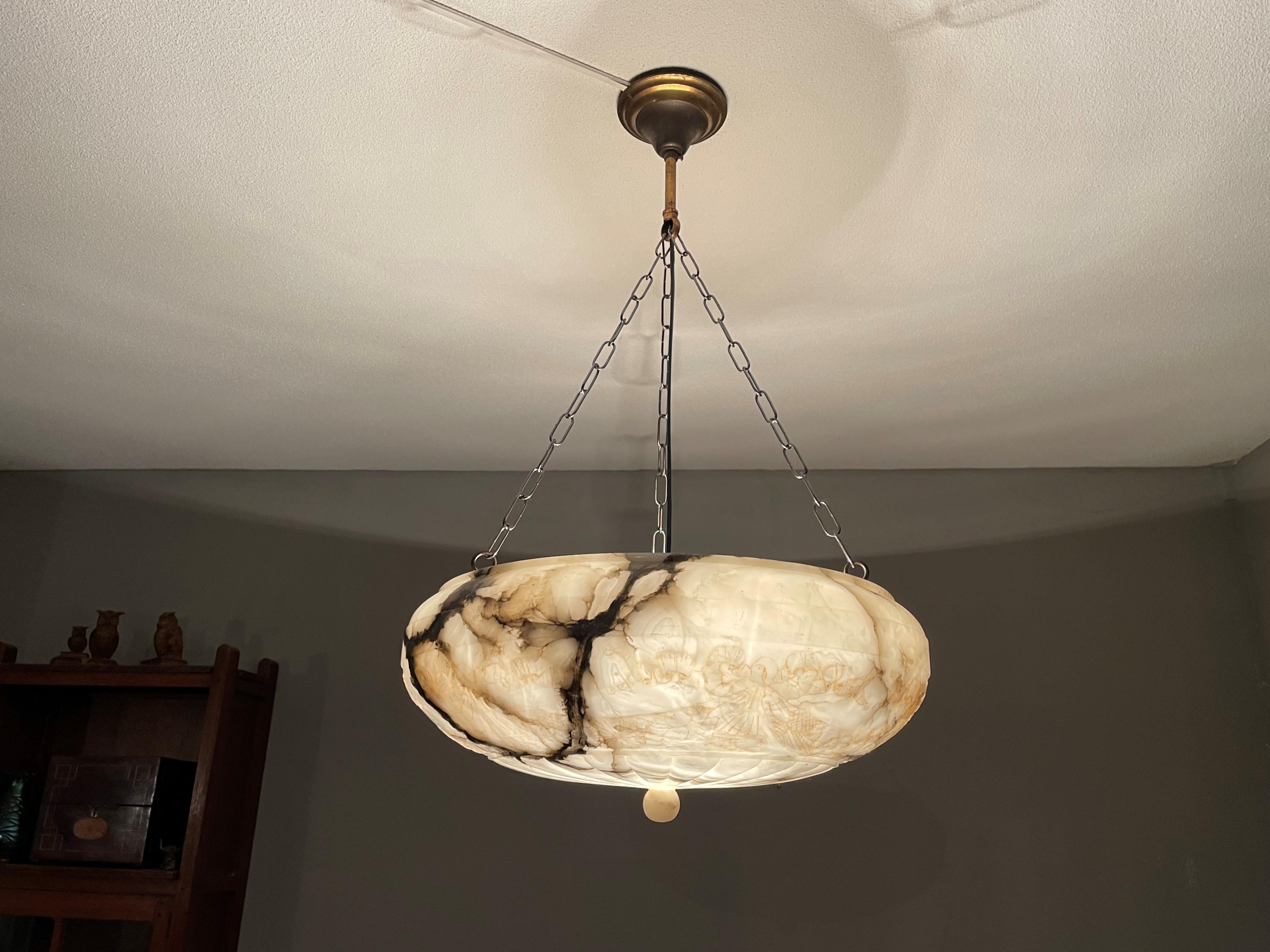 Top class light fixture with a stunning alabaster shade of 20 inches in diameter.

Thanks to its unique design, its large size and its excellent condition this alabaster chandelier will light up both your days and evenings. Apart from the bronzed