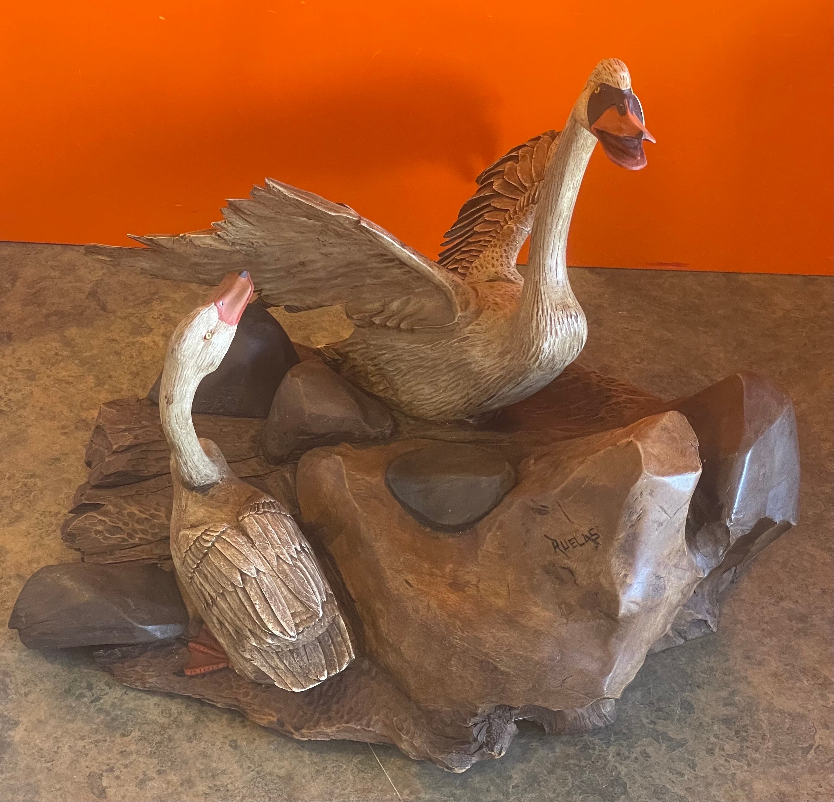 A very nice large hand carved duck sculpture by Miguel Ruelas, circa 1980s. The detail, craftsmanship and painting in this piece is lifelike and truly amazing; they look absolutely real! The sculpture is carved from a single piece of solid wood nd