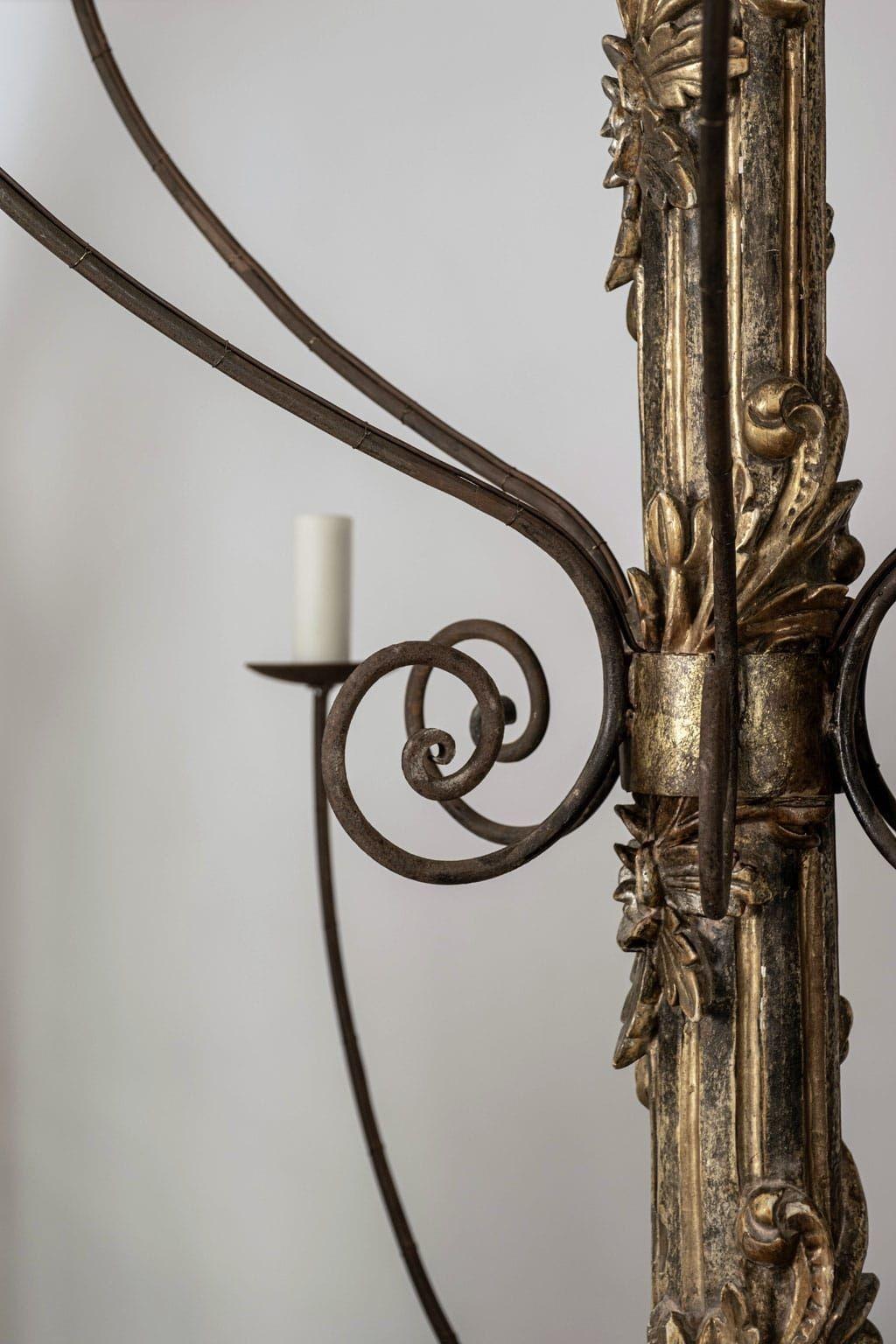 Massiccio lampadario italiano a dodici bracci intagliato e dorato a mano, appena cablato. Ghirlanda in legno dorato intagliata a mano intorno al corpo scanalato dipinto di verde e dorato. Restaurato con dodici bracci di ferro forgiati di recente in