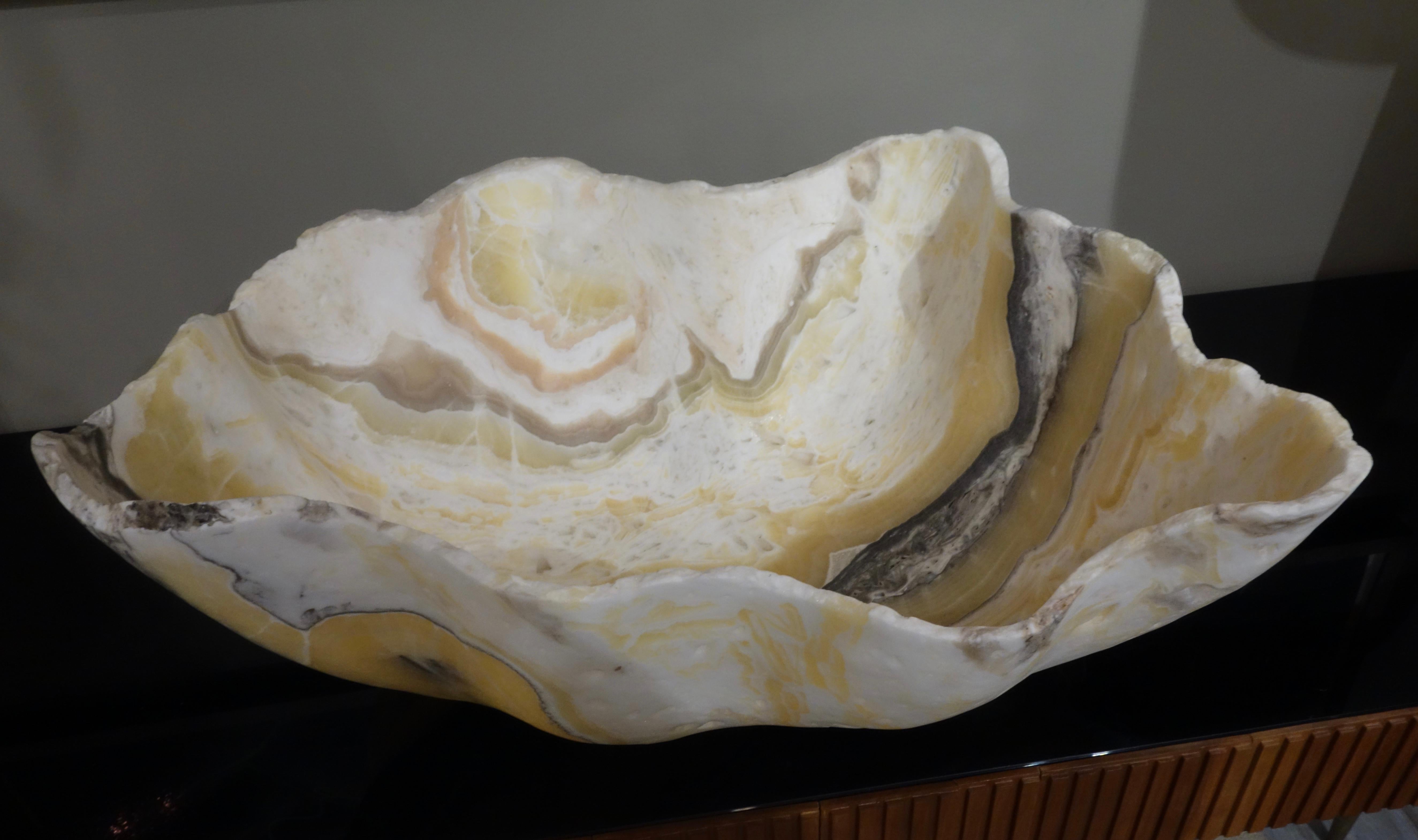 A very large hand carved Mexican raw edge onyx bowl or centerpiece in undulating colors of white, gold, charcoal, taupe and blush with natural negative spaces.