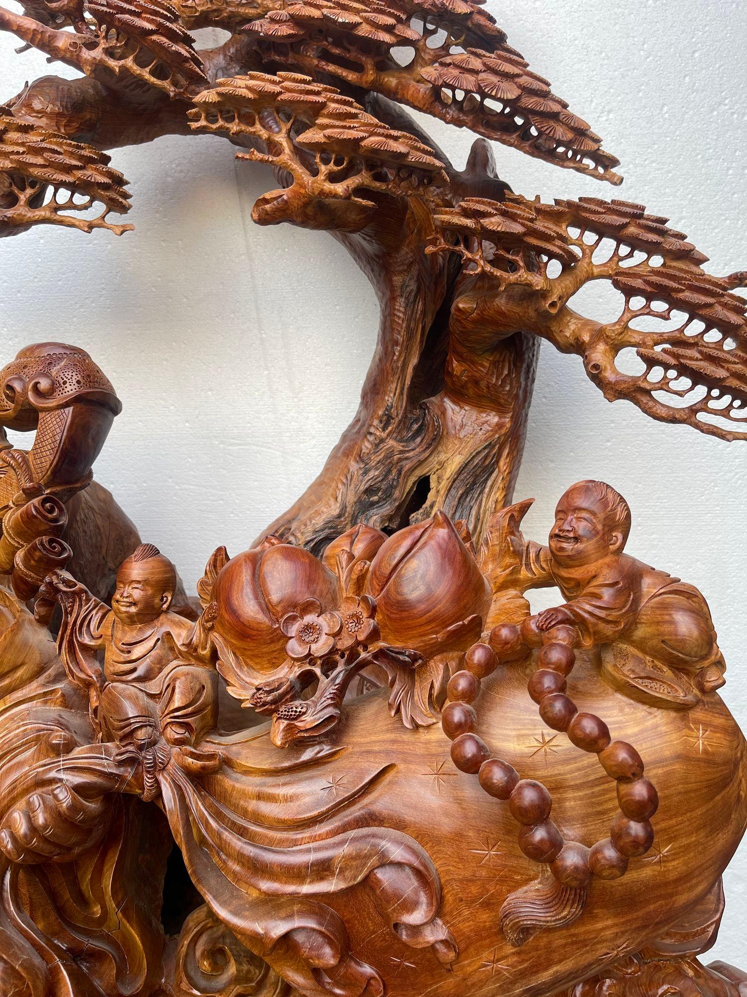Metà XX secolo Grande Buddha Hotei intagliato a mano in legno di Padauk con bambini e albero bonsai degli anni '50. in vendita