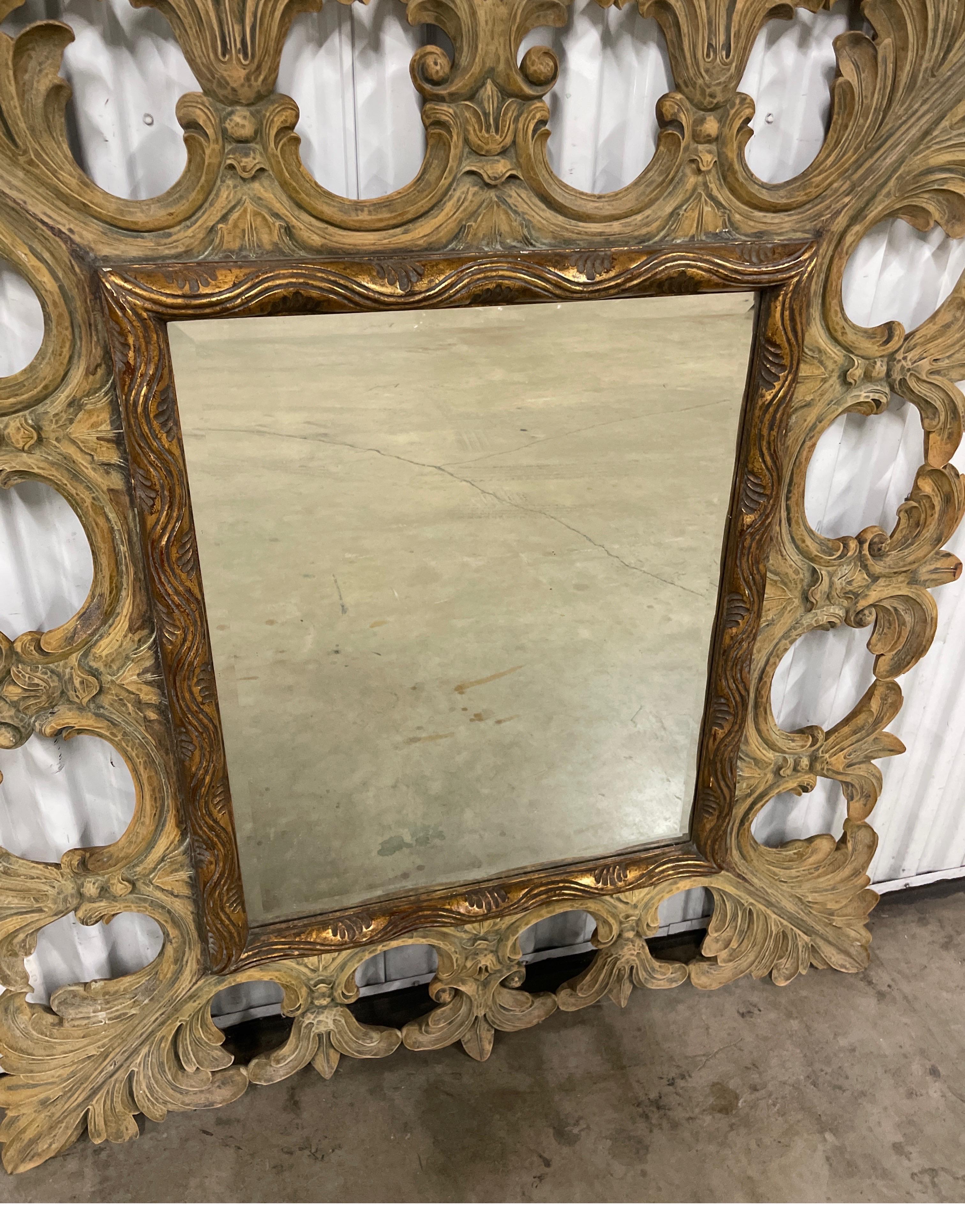 Miroir vintage sculpté à la main avec des motifs de feuilles par Harrison & Gil.  Ce miroir peut être suspendu verticalement ou horizontalement.