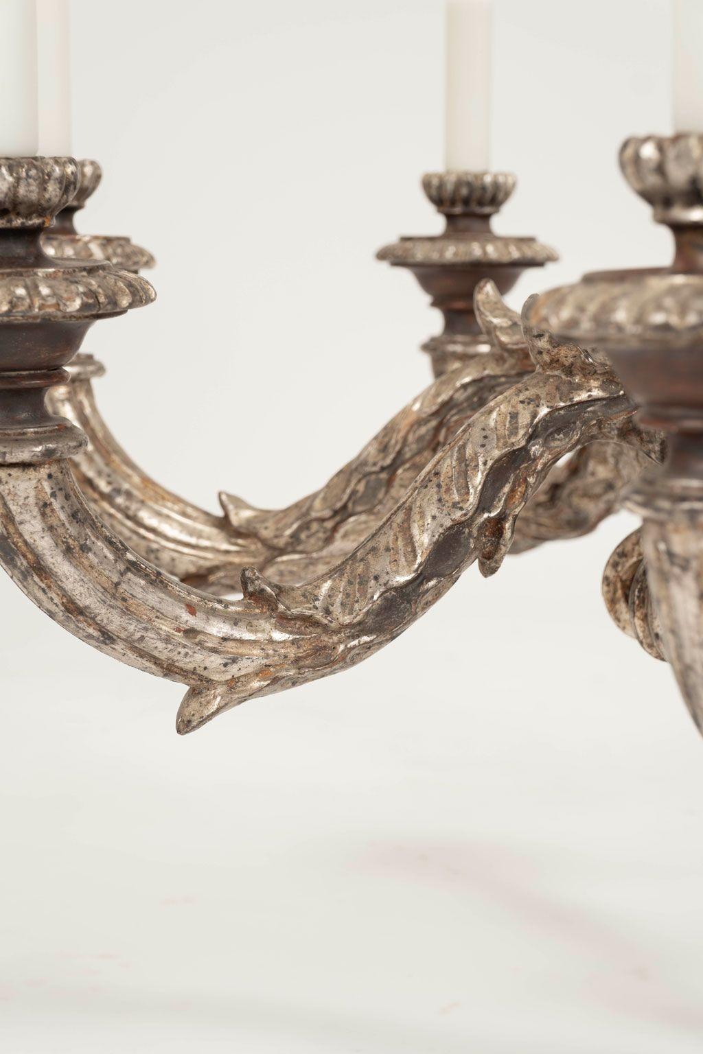 Grande lampadario in argento dorato intagliato a mano con otto bracci. Lampadario francese del 1930-1959 circa, intagliato a mano in legno in una scala bella e generosa. Finitura originale argentata con alcune perdite e patina. Cablata di recente