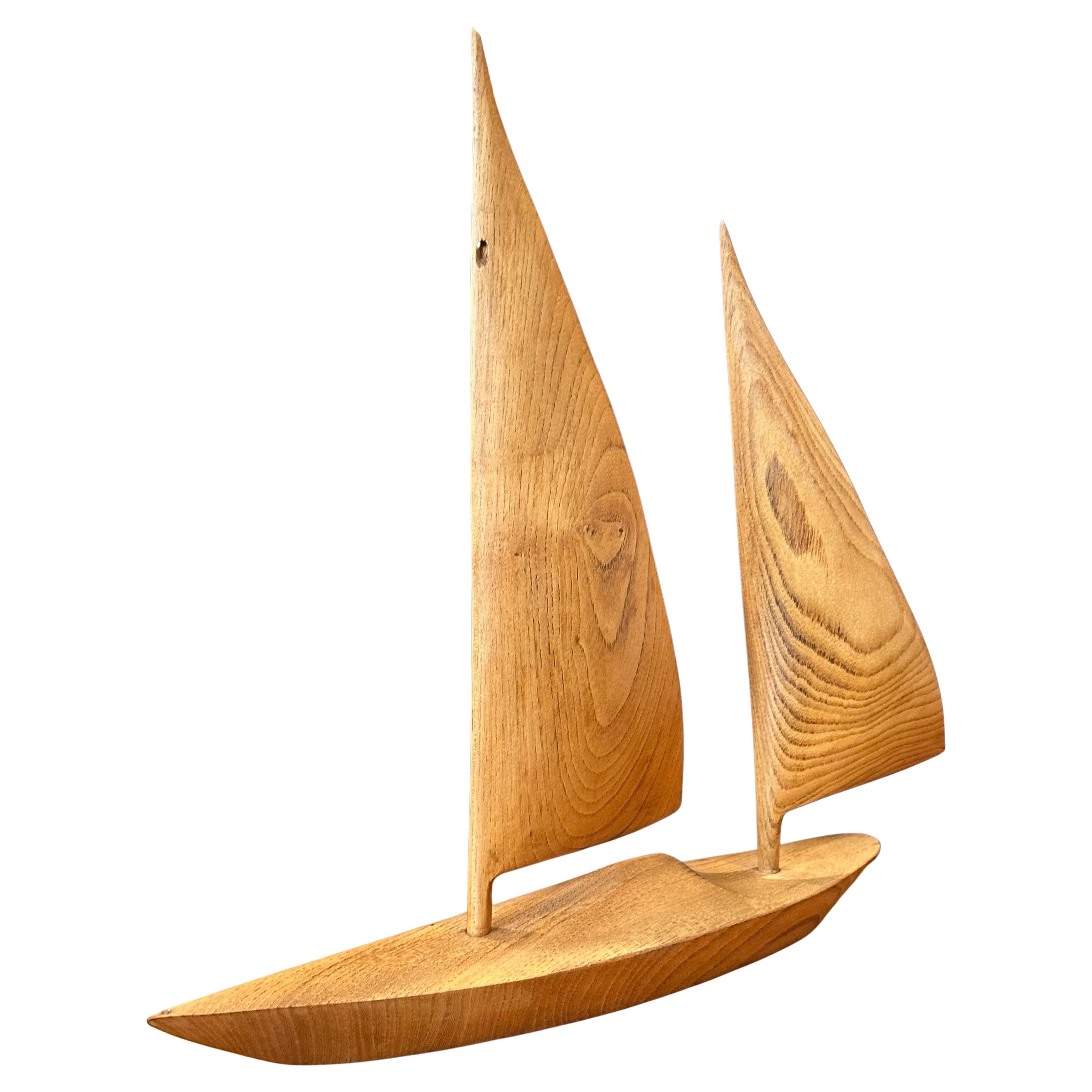 Large hand carved teak sailboat sculpture, circa 1970s. The piece is in very good vintage condition with no chips or cracks and measures 14.25