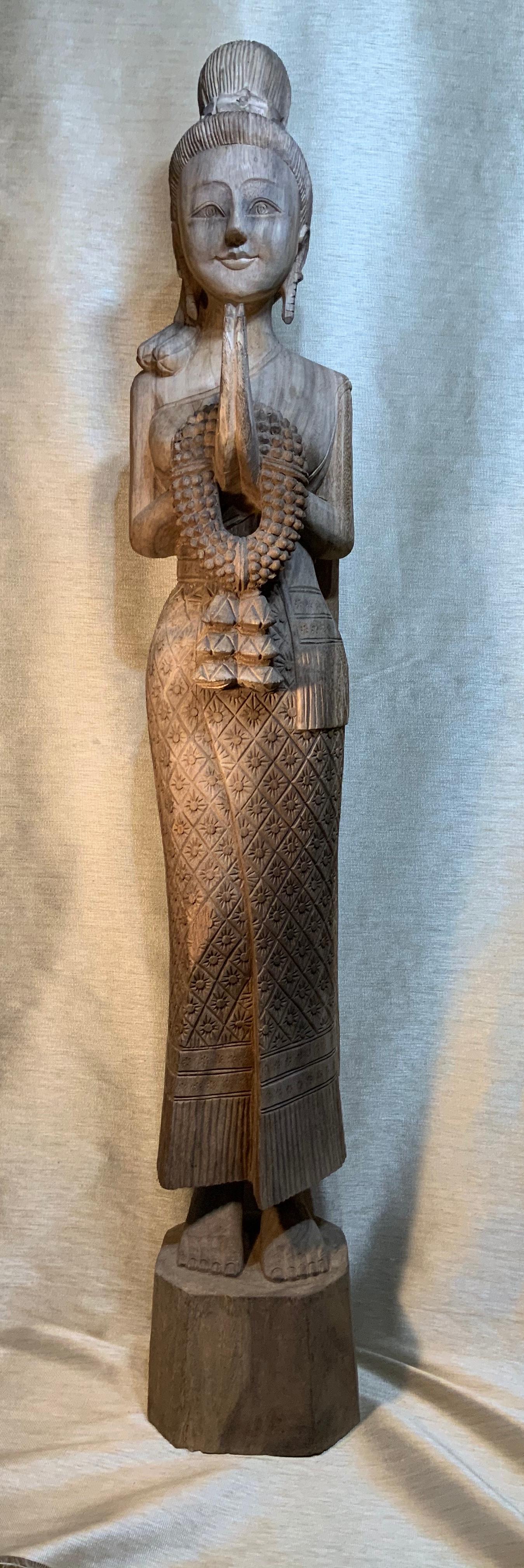 Elagent Quan Yen statue made of hand carved wood, beautiful facial expiration, hands forward holding bouquet of flowers in grace and goodwill. Exceptional looking dress with unusual vivid carving motifs make this beautiful statue a one of a kind