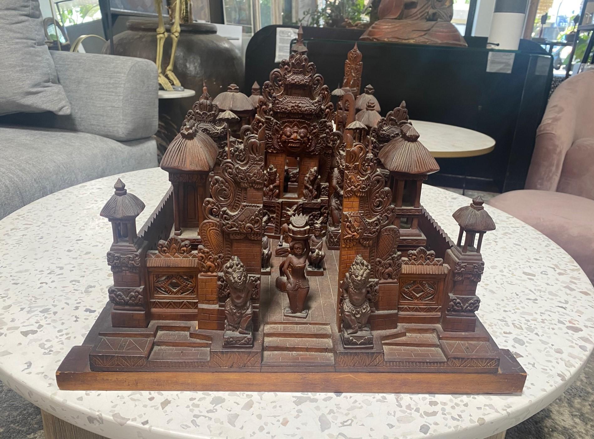 A large, unique, masterly carved Indonesian sculpture featuring a temple village scene with tall pagodas, dancers, musicians, monks, carved Indonesian gods and spirit figures, etc...   The sculpture is carved from heavy, solid wood (perhaps teak or