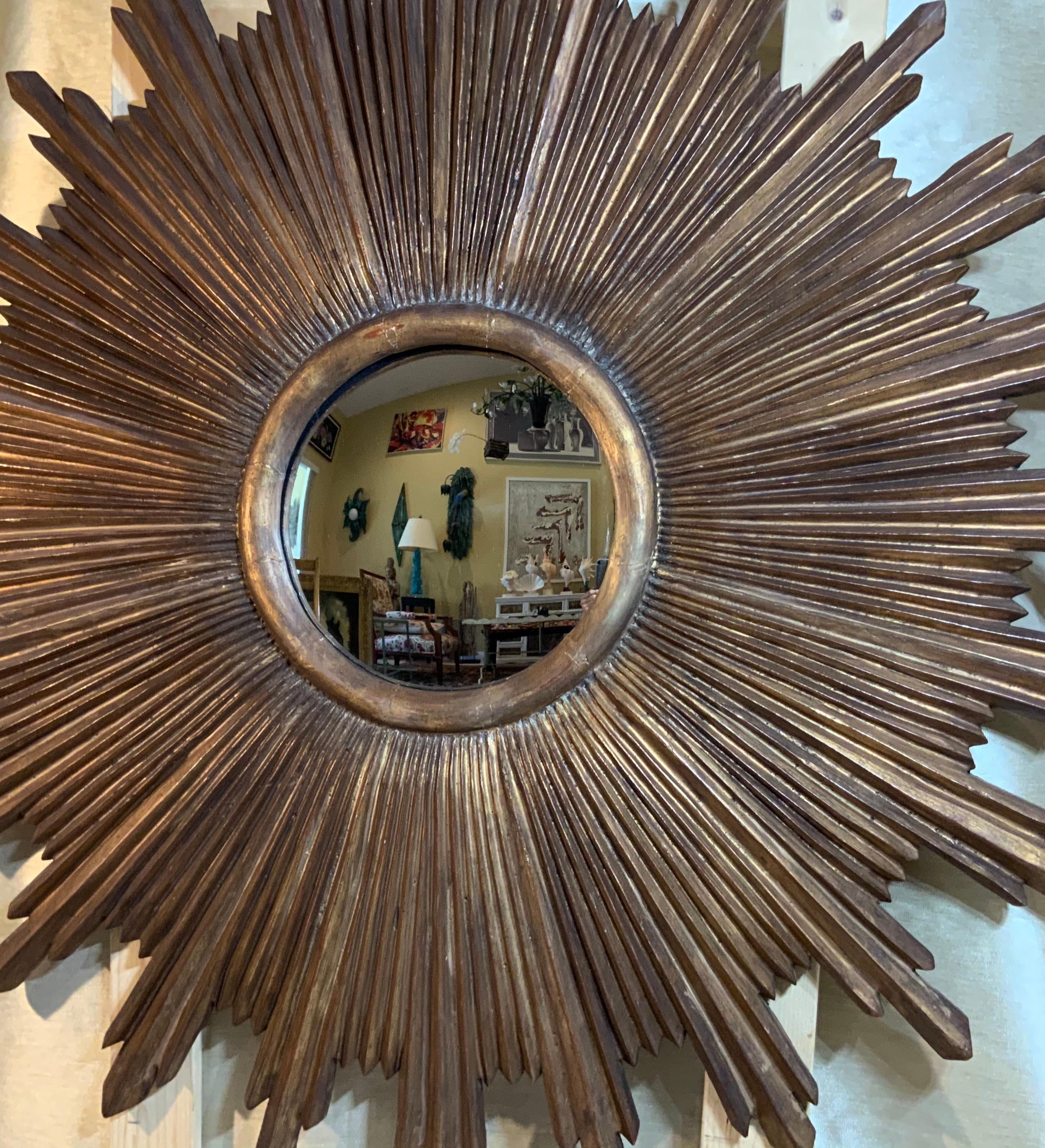 Elegant large sunburst mirror made of wood, hand painted muted gold over gesso with the original curved mirror exceptional affect when hang on the wall.
Mirror glass size only 12”.