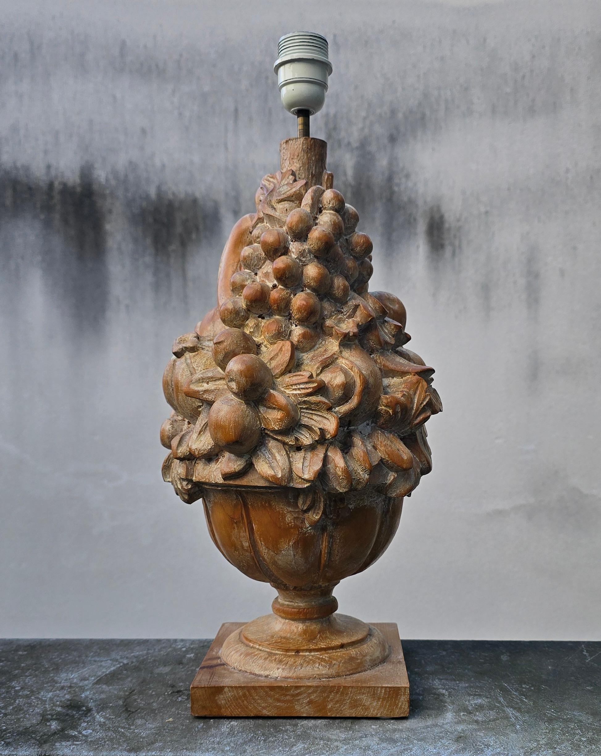 Skulpturale, handgeschnitzte Holztischlampe mit reichhaltigem Fruchttrophäenmotiv. Italienisch oder Französisch, 1950er Jahre. Schöne rustikale Patina. Eine E27-Fassung. Schirm nicht enthalten.

Eine auffällige, handgeschnitzte Holztischlampe, die