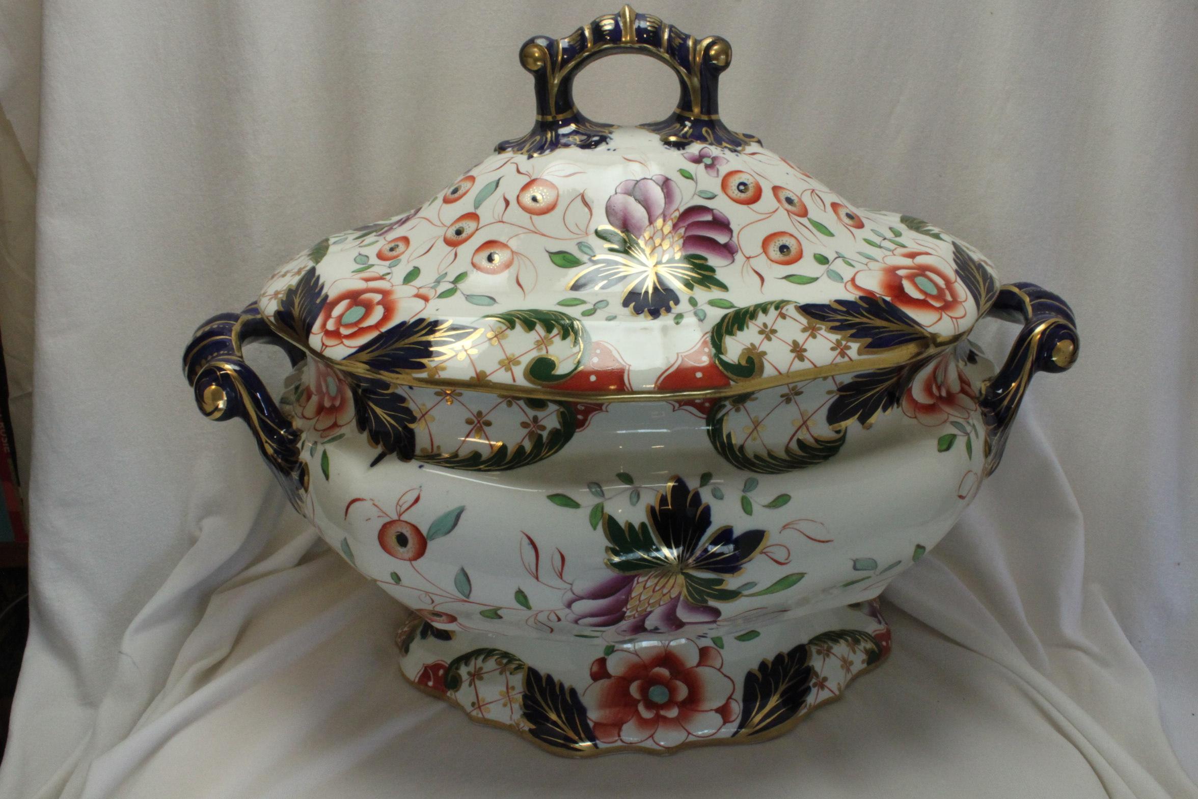 This large and very decorative Davenport lidded soup tureen is decorated with a hand coloured and gilded Imari pattern-Davenport's pattern number 76. The pattern features stylised flowers and berries done in the traditional Imari colours of