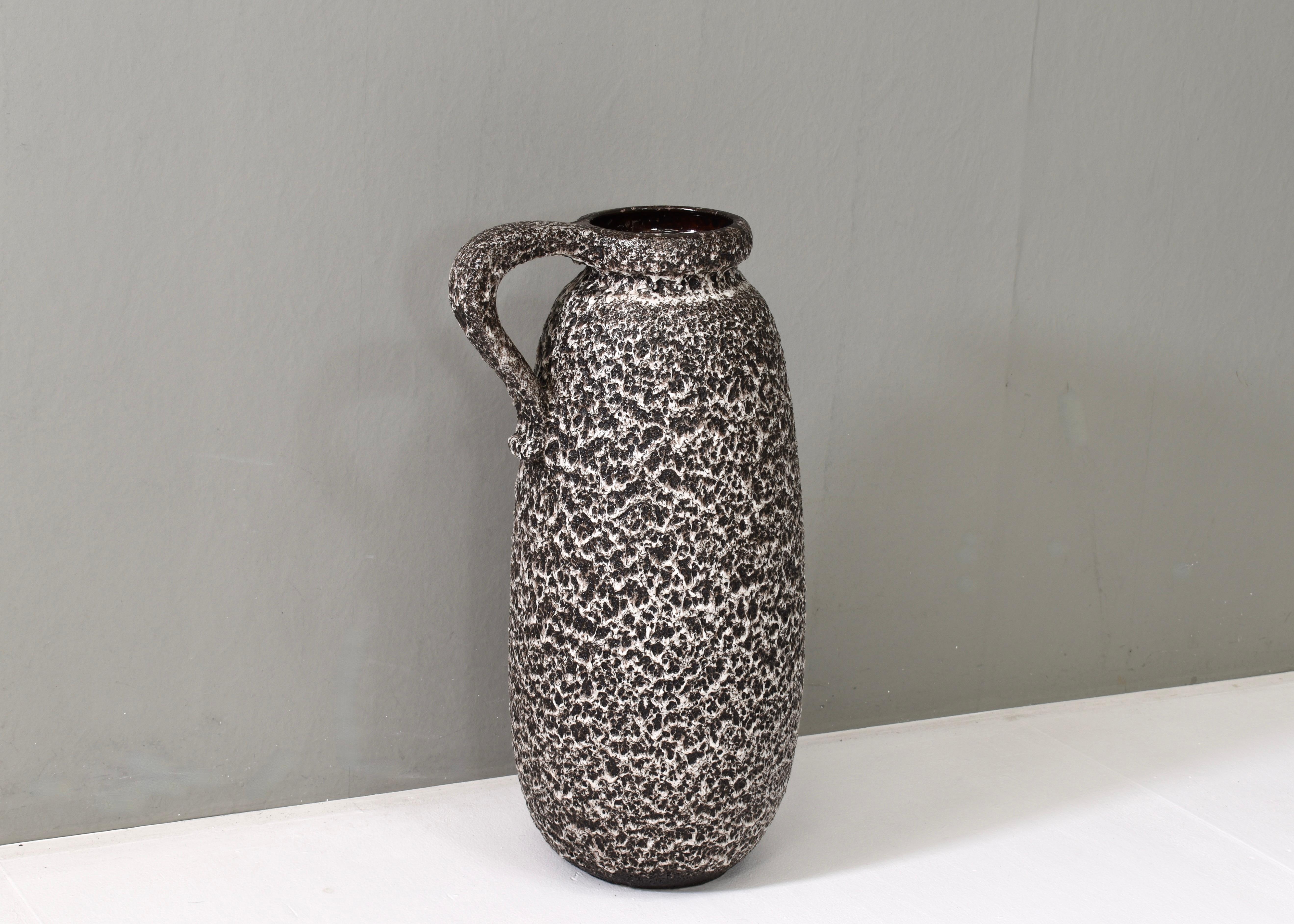 Vaso in ceramica di Scheurich, Germania occidentale, con texture ruvida e maculata e manico in alto. Ha un aspetto terroso e organico, probabilmente dovuto a una specifica tecnica di smaltatura che crea una finitura granulosa. Questo tipo di