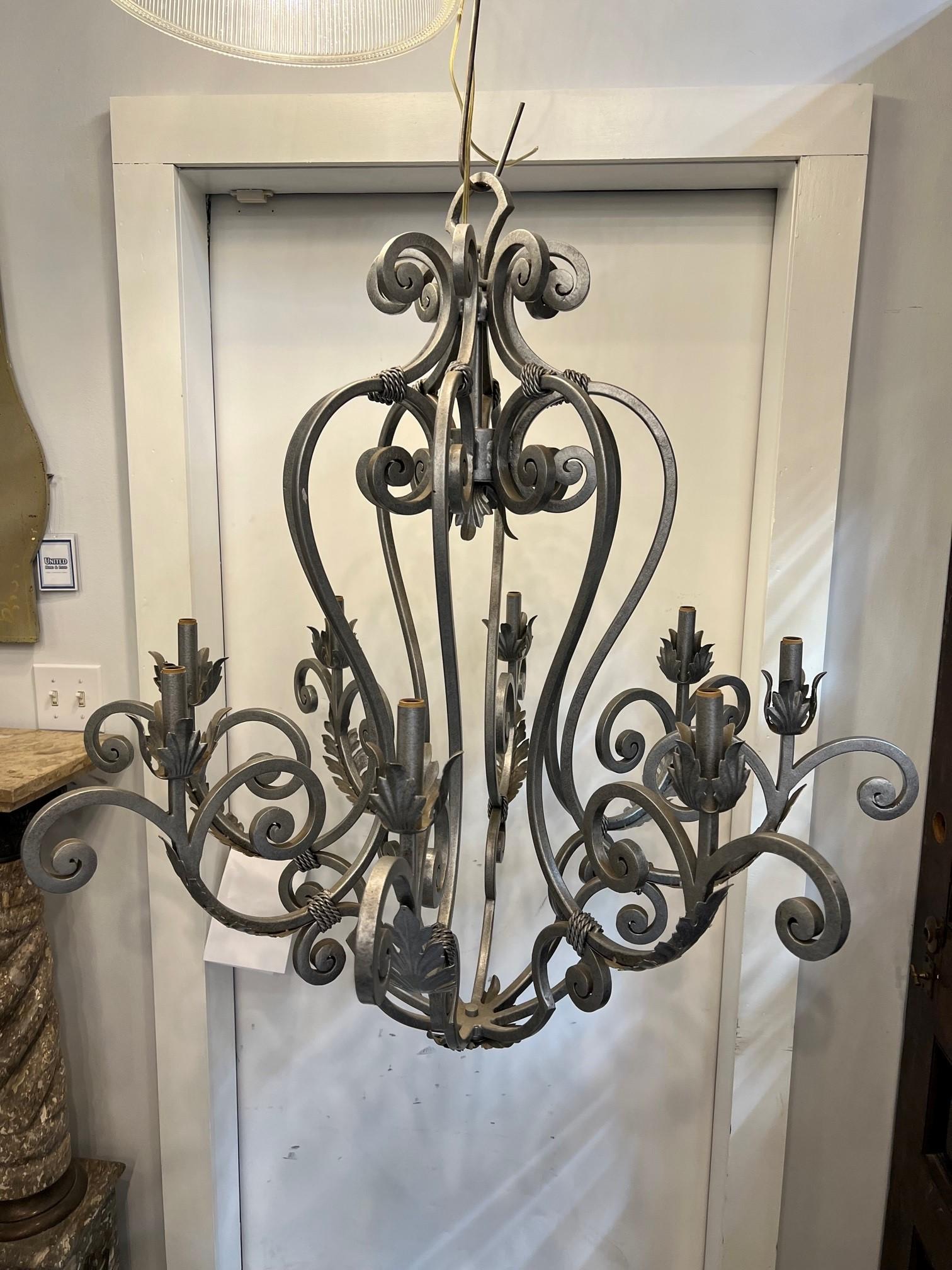 Beautiful decorative iron chandelier with eight lights. Hand forged with curved arms and leaves with a twisted rope design. A great piece to compliment any interior, would look great over a large table or Island, it's a nice size. Has a silver