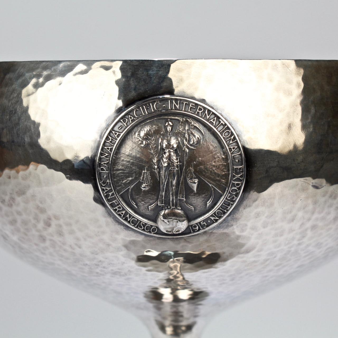 A wonderful art deco chalice-form trophy by Shreve & Co. With overall hand hammered decoration, the large cup is supported by a thin vasiform pedestal and foot.

Fashioned for the Templar Knights for the Panama-Pacific International Exposition, it