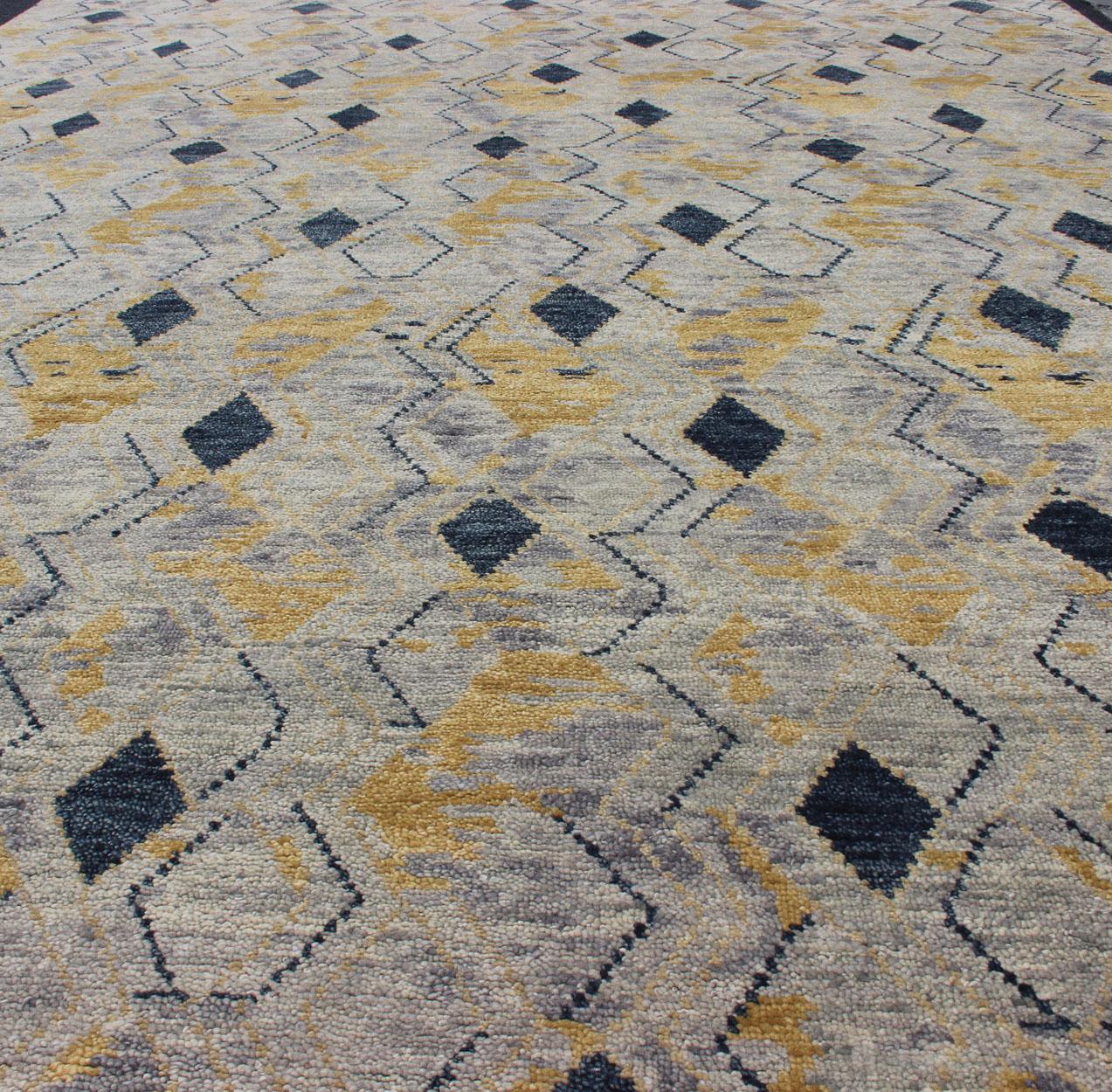 Large Modern Rug With Diamond Design in Yellow and Blue. 

Measures 10'1 x 13'10
This modern rug features a blue and yellow diamond pattern, lining the entire rug in vertical columns. The background is a light gray, giving this piece a rustic charm.