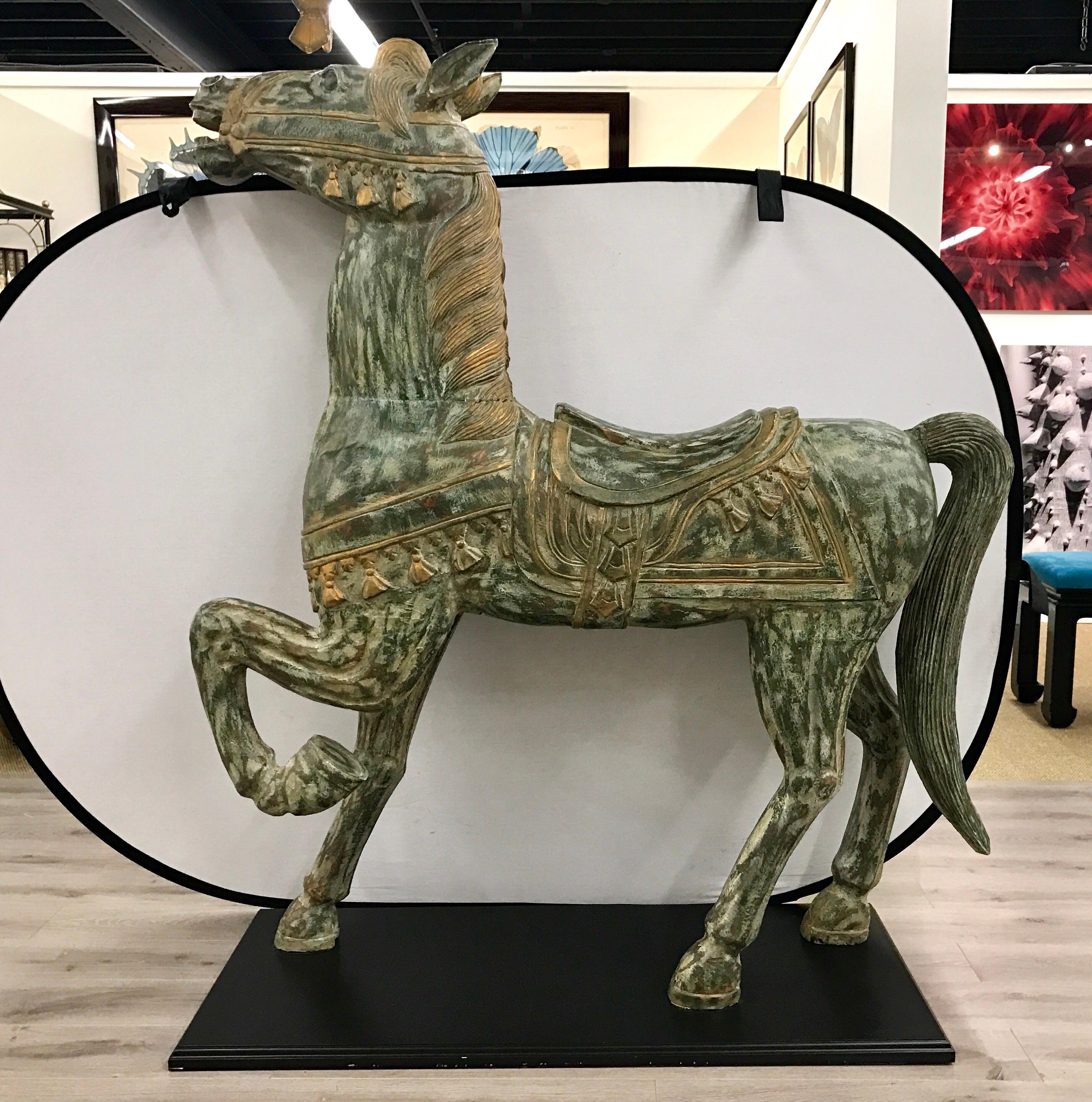 Standing just over five feet tall on a black mount, this hand-painted carved horse is quite unusual.
