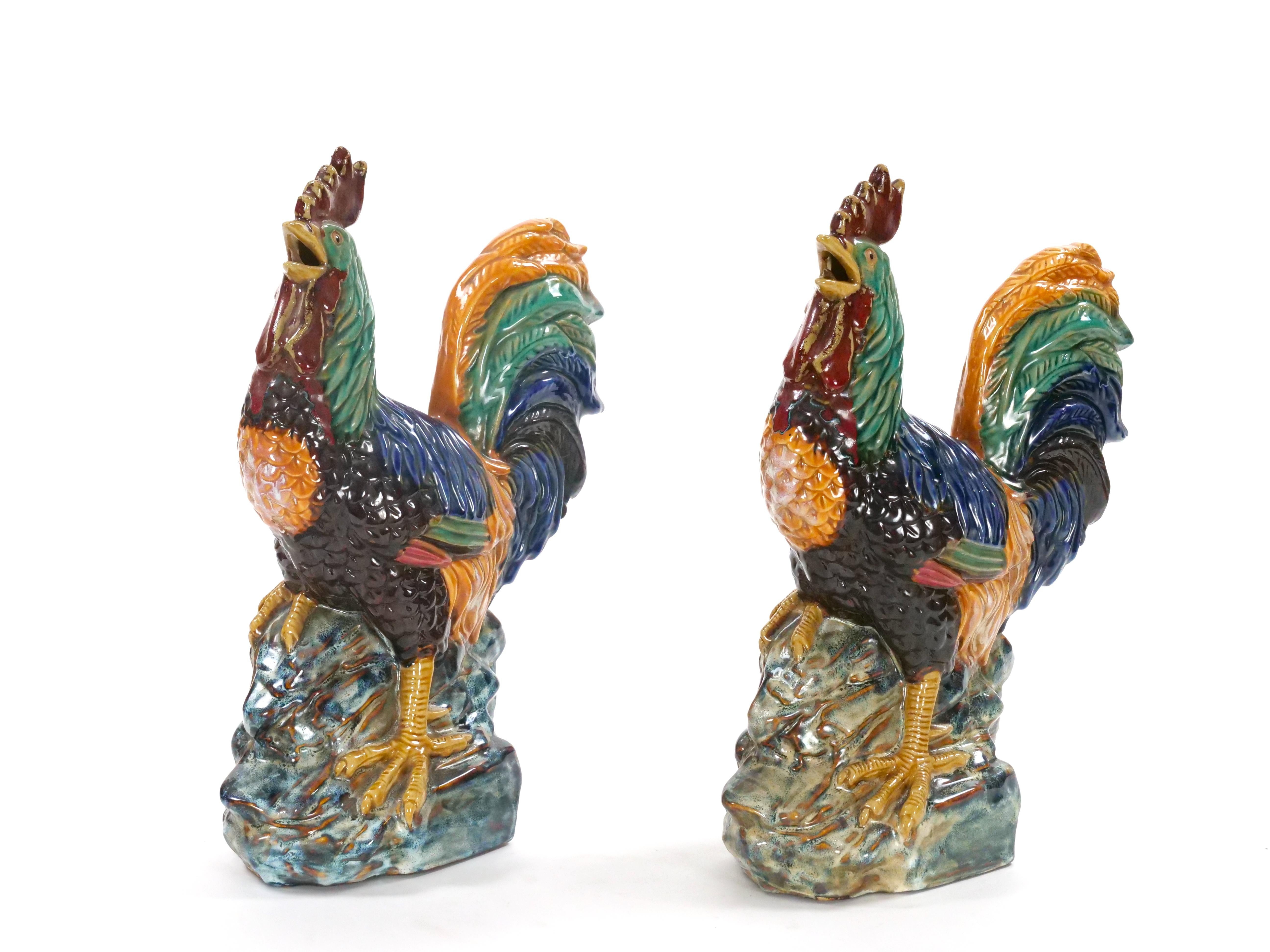 Te presentamos una exquisita pareja de figuritas de gallo de porcelana inglesa pintadas y decoradas a mano. Cada gallo presenta atrevidos y vibrantes tonos amarillos, verdes, azules y rojos, que capturan la esencia de estas magníficas aves en un