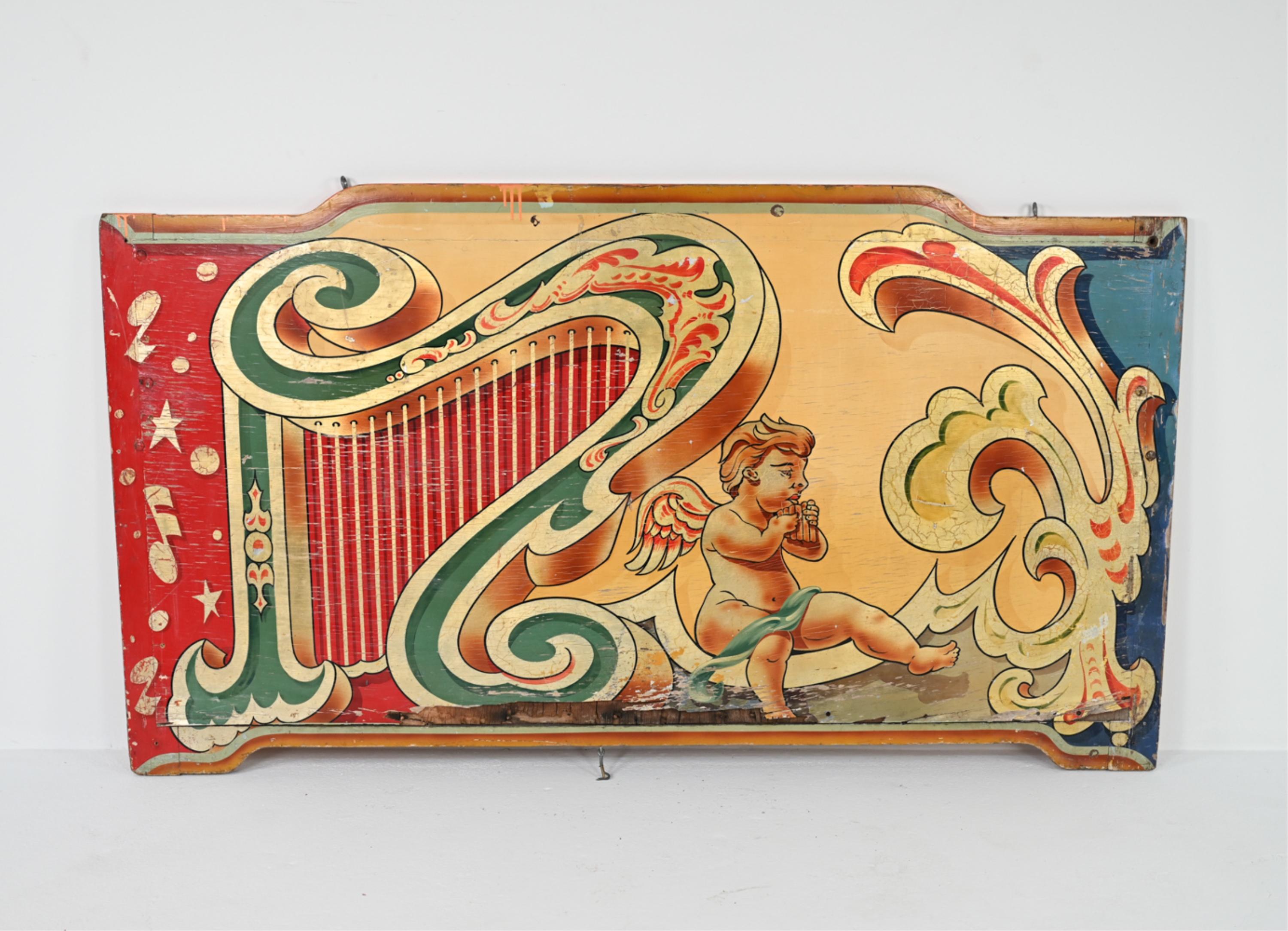 Bring an unusual piece of folk history into your home with this stunning early 20th century rounding board salvaged from a carnival. With hand-painted designs of putti and harp motifs and gold leaf pigment, this board is a whimsical, decorative