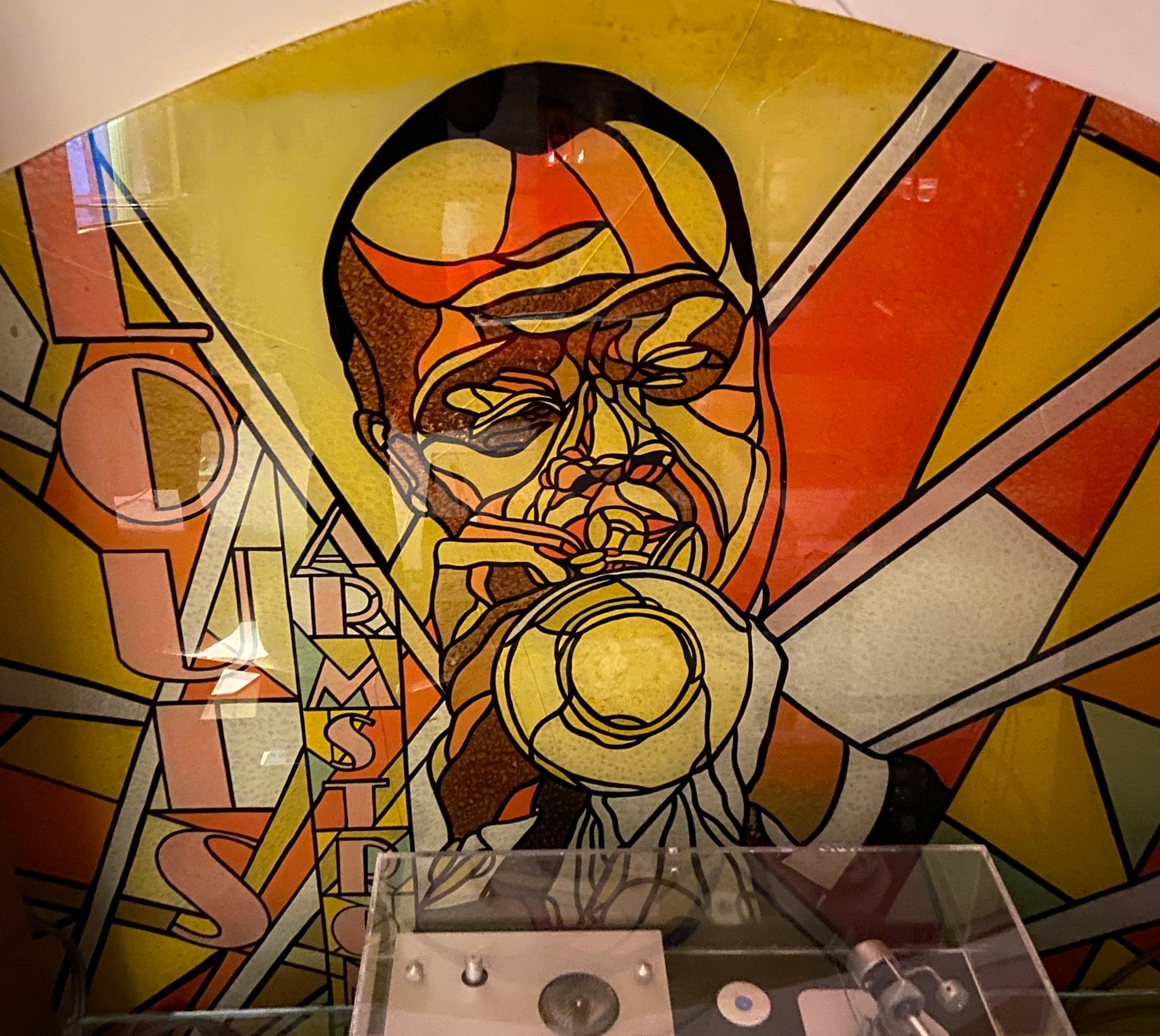 A large hand painted glass panel / window featuring Jazz trumpeter Louis Armstrong. 
Stylised form, with Art Deco painted lettering to the left-hand side. Double laminated glass. 
The vendor came in to possession of this piece after taking