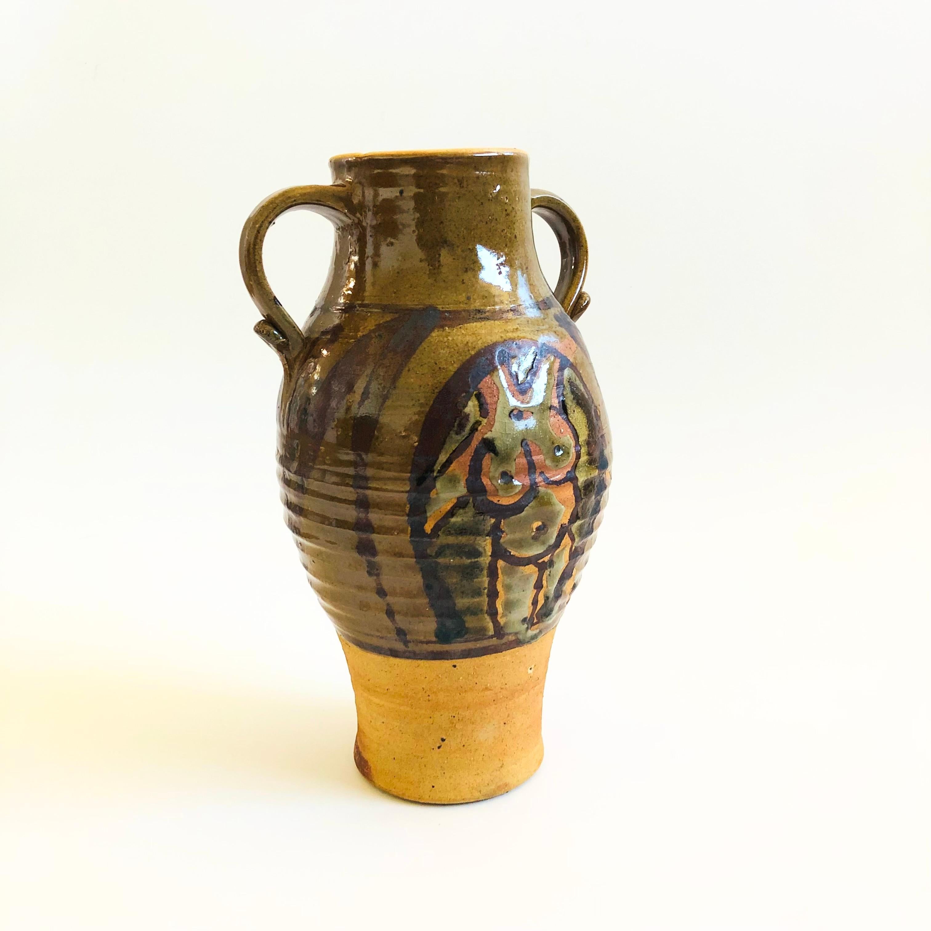 A large vintage studio pottery vase. Beautiful dark earth tone glazes with a contrasting natural clay base. Features hand painted designs of a male and female nude on each side. Small handles formed on the sides. Signed by Mark Archer on the base.

