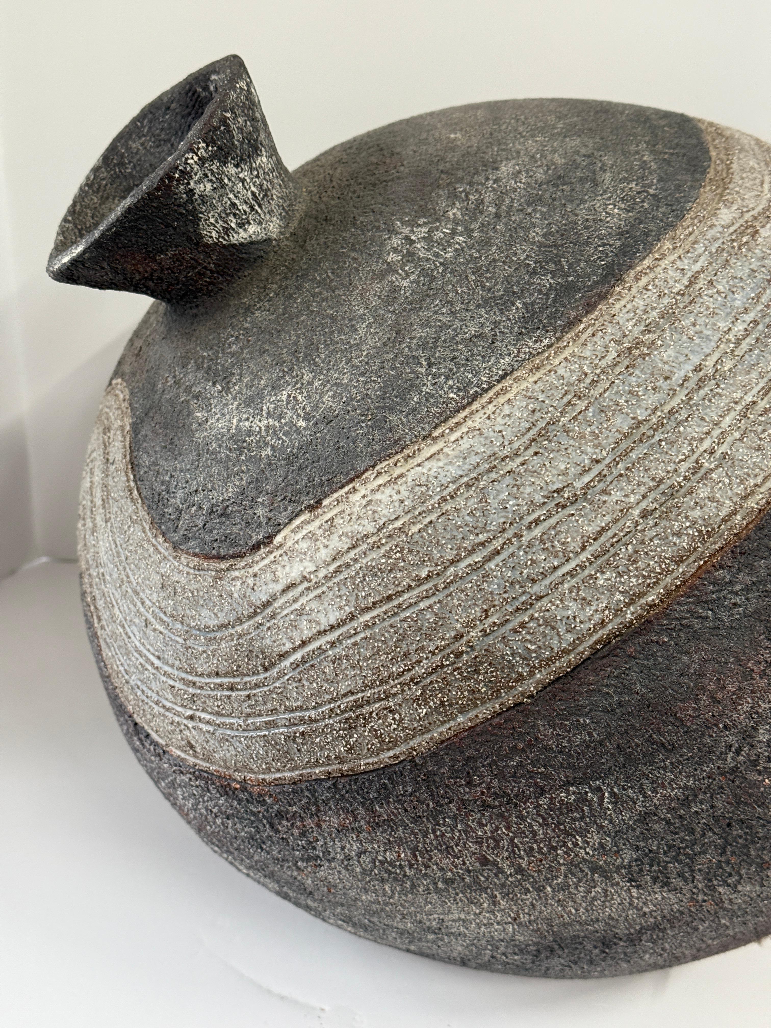 Adquirimos un grupo de piezas de cerámica bastante grandes y macizas, todas de principios de los años 90. Ésta es bastante inusual, una gran vasija de cerámica hecha a mano. Tiene una gran forma y está bien ejecutada. Un inusual esmalte rugoso con